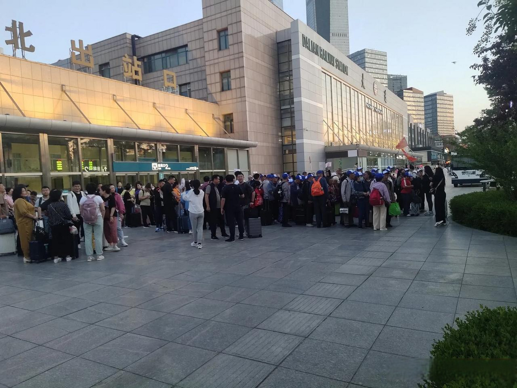 大连火车站北出口附近,有不少人在出站口附近背着书包,站着整齐的队伍