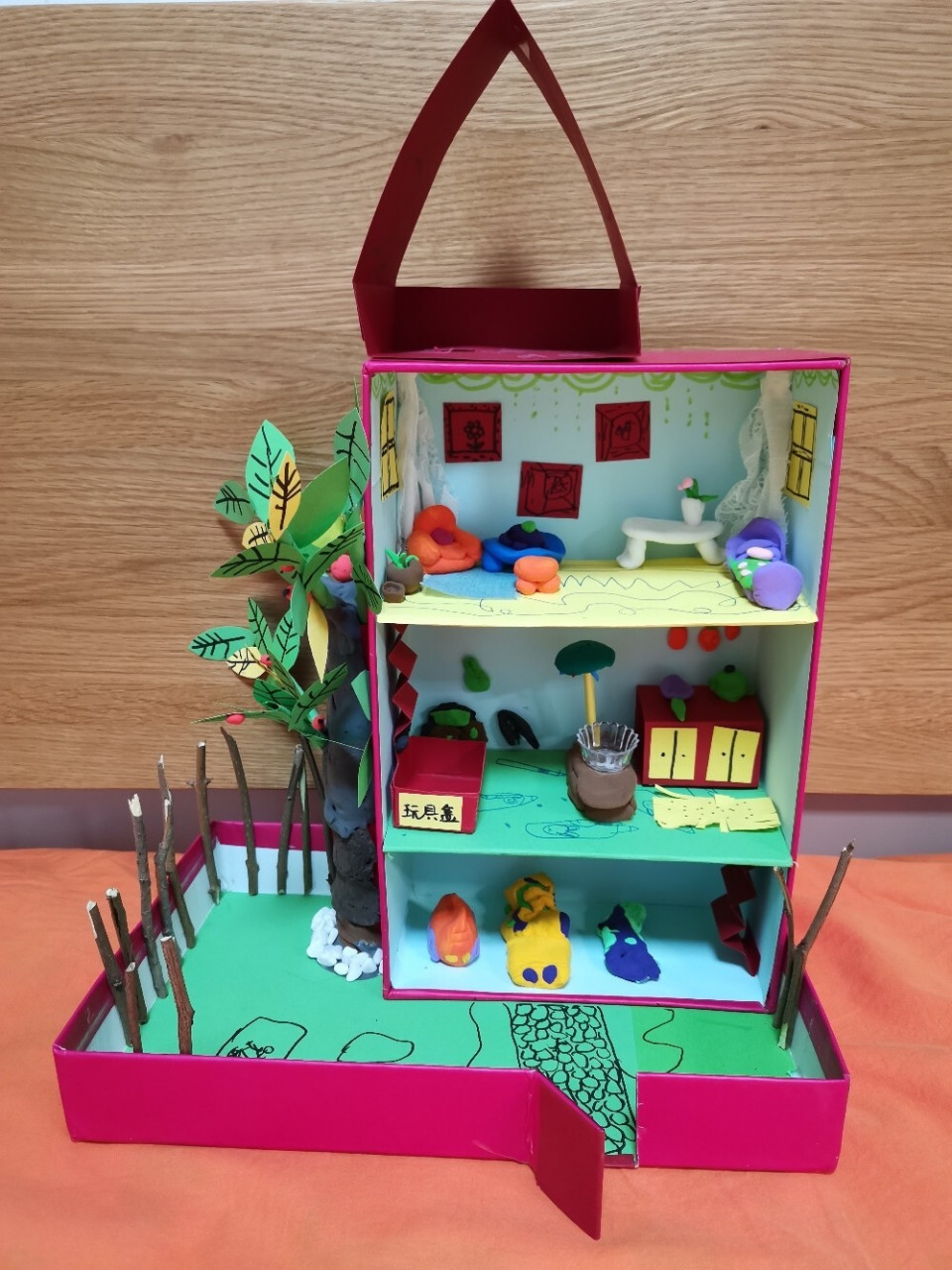 跟孩子一起用鞋盒制作一个三层小洋楼,再用橡皮泥制作一些小家具,最后