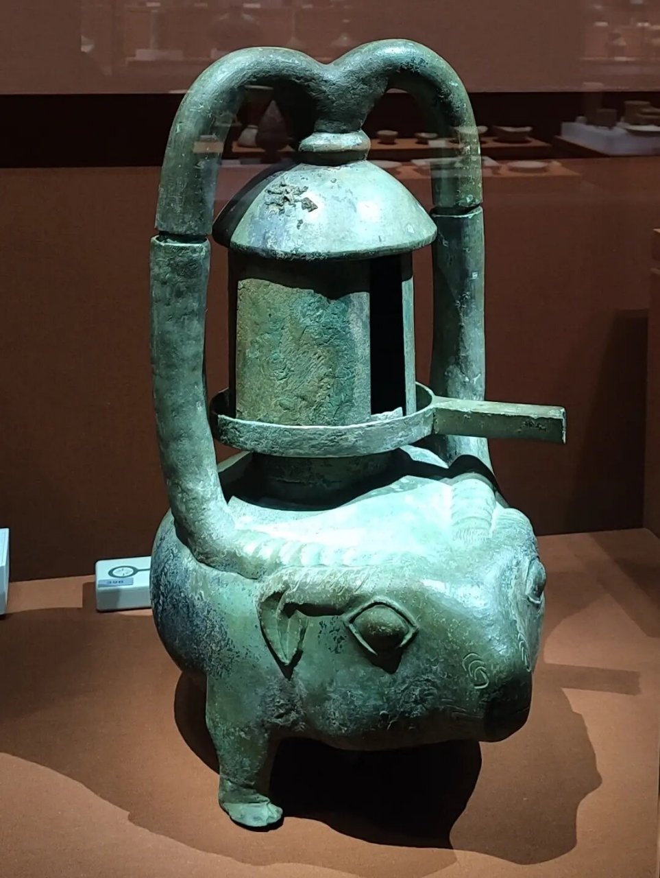 此灯颜色淡绿,形象似牛,耳下垂,腿矮小,造型生动.