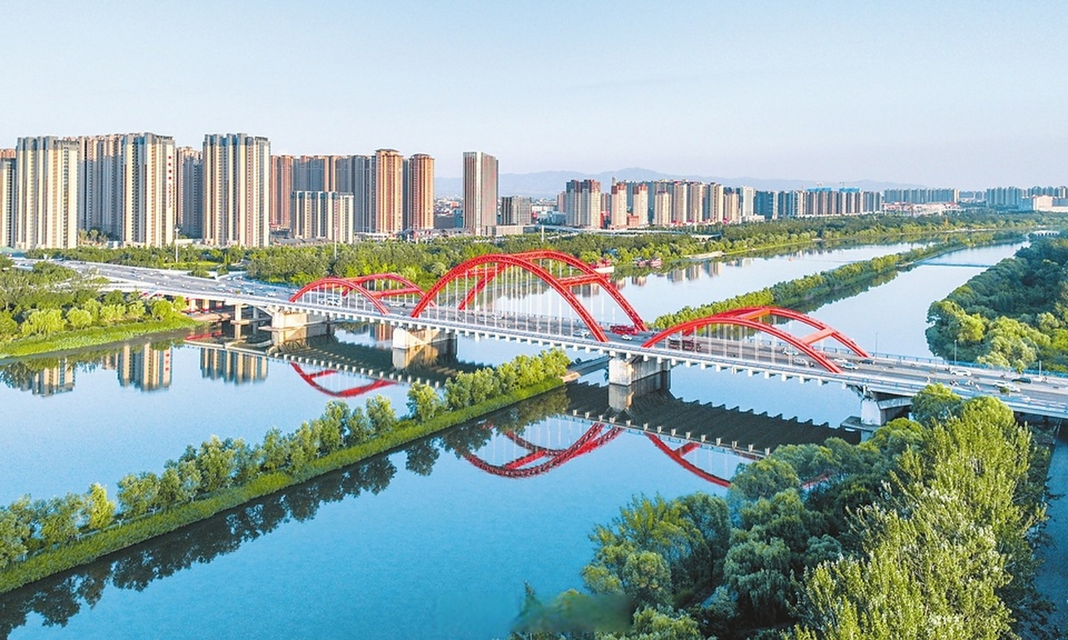 盛夏时节,临汾市汾河公园绿意盎然,层次丰富的园林景观和建筑倒影构成