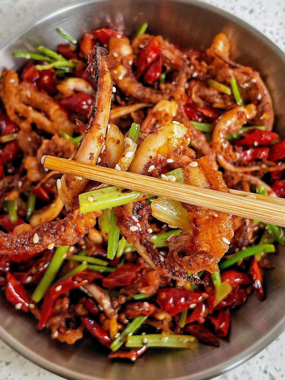 香辣酥脆的干煸鱿鱼须 食材:鱿鱼须,小香芹 调料:姜,蒜,花椒,干辣椒