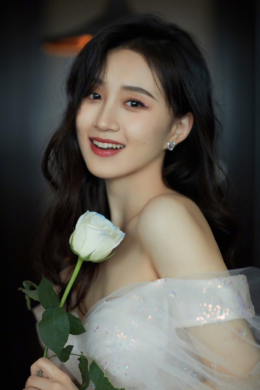 演员@程金铭 释出春日春花大片,身穿白色纱裙,手捧鲜花,表情灵动,氛围