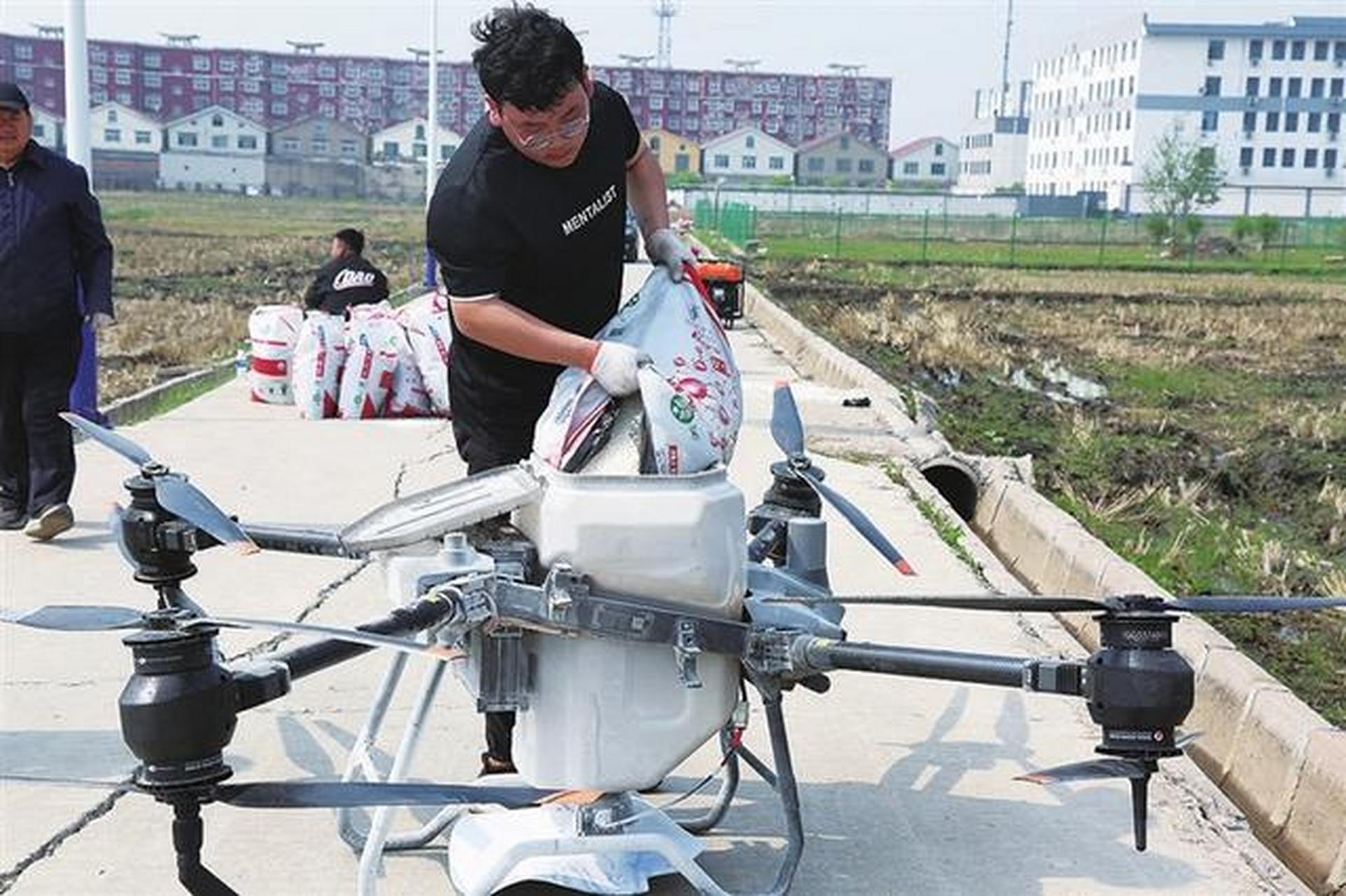 太原头条太原5月15日,晋源区王郭村技术人员在田边将肥料装进无人机.