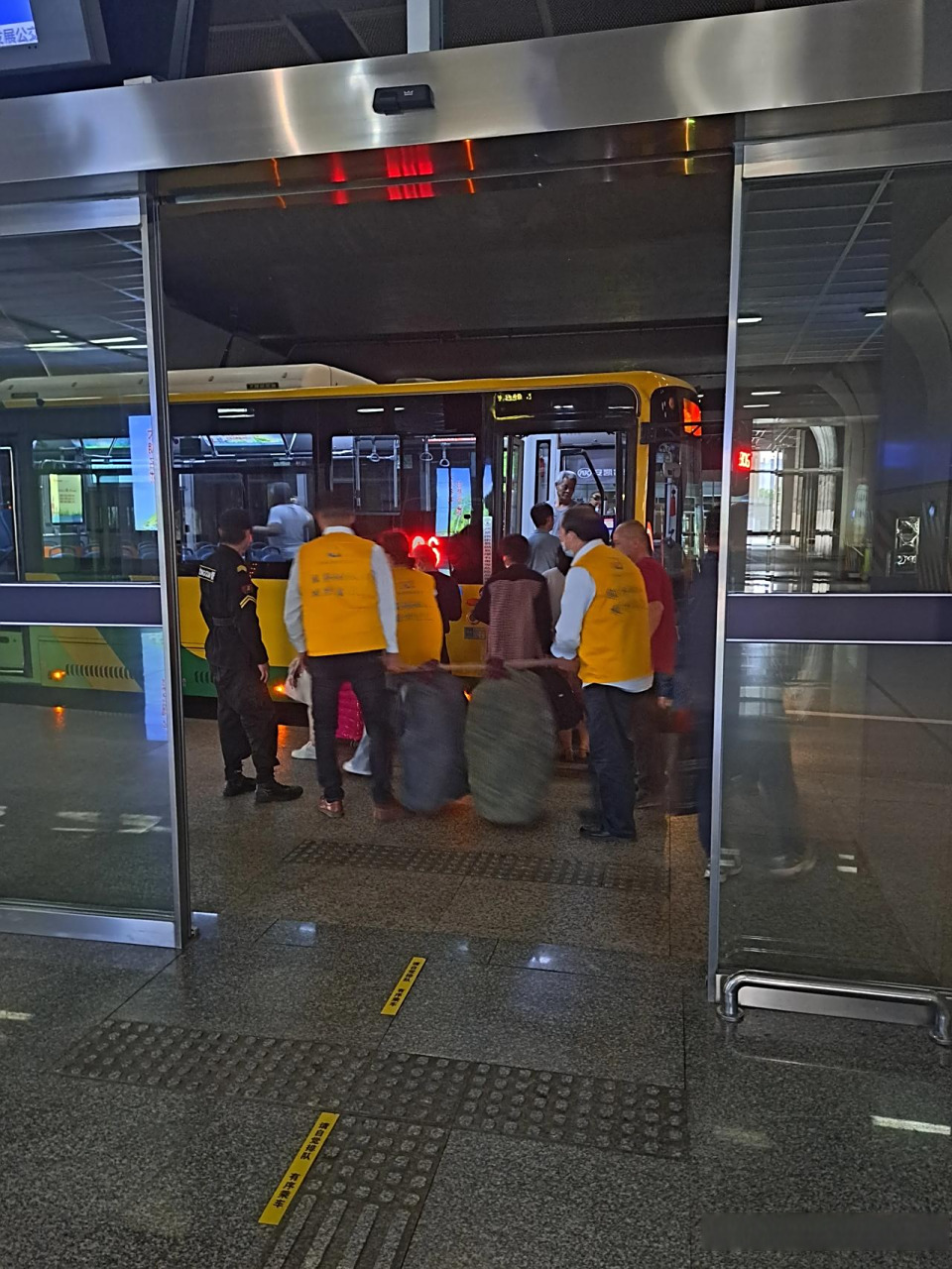 合肥南站,公交站台志愿者帮助别人抬行李,合肥有大爱.