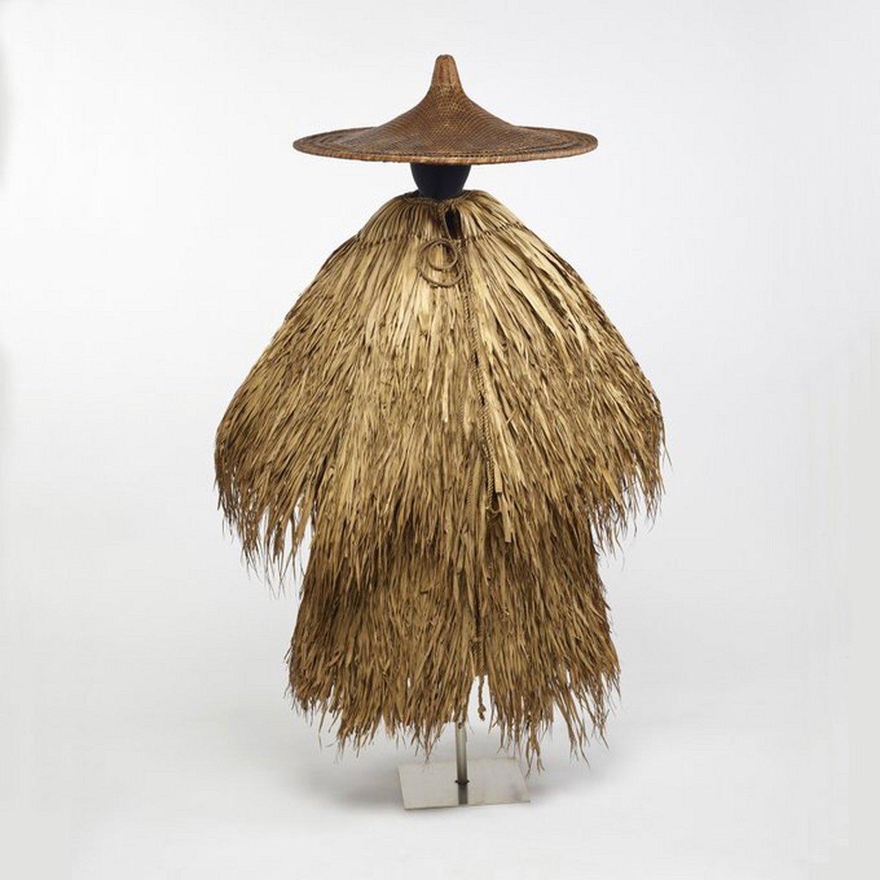 一件中国古代雨披,一般由棕榈叶子制成,形式像茅草屋顶一样密密麻麻地