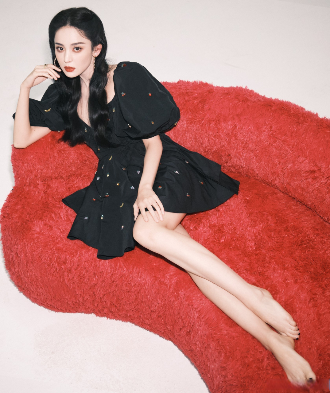 美女明星古力娜扎坐在红色沙发里大秀美腿玉足