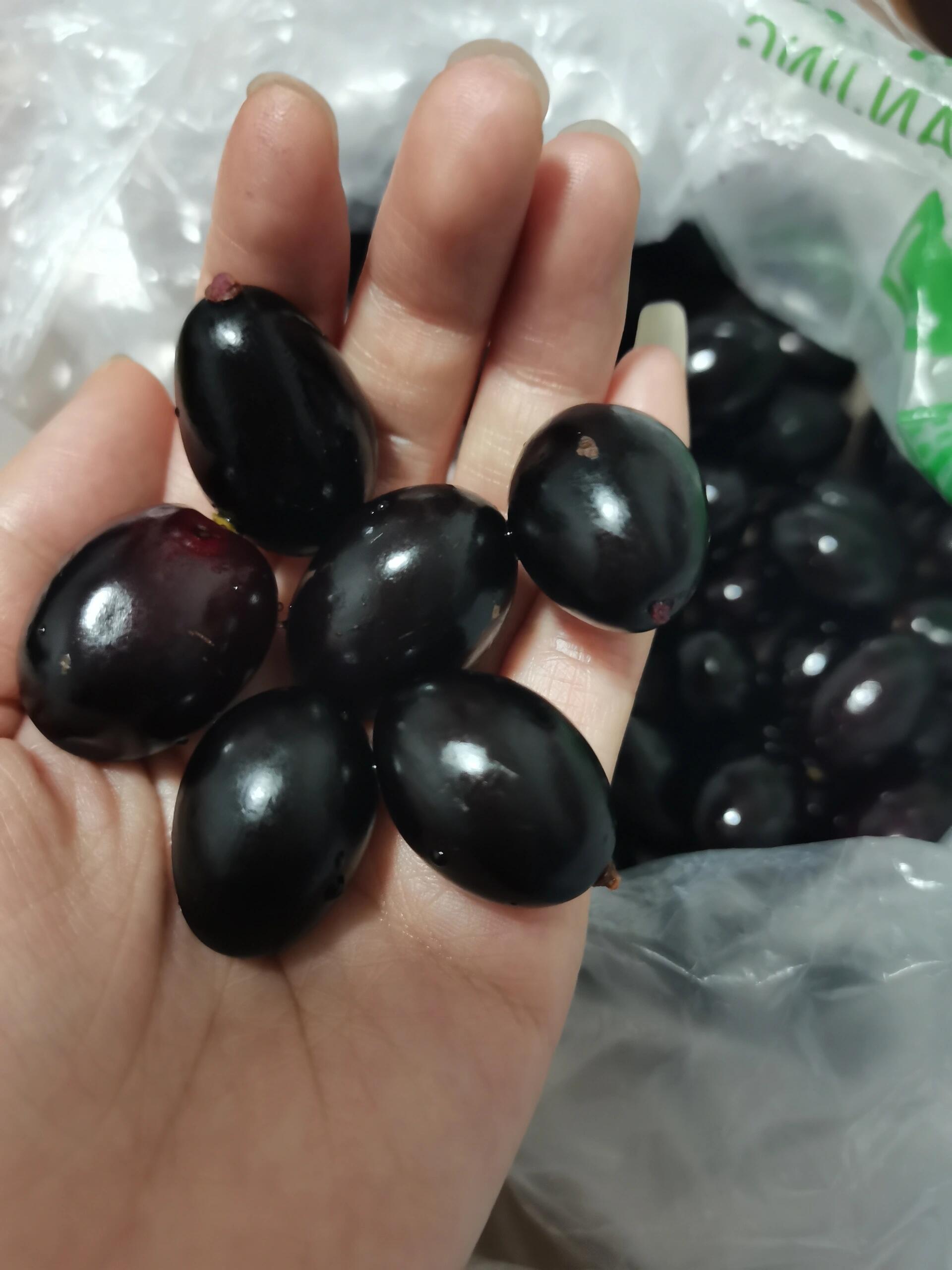 老板说叫乌龙珠,黑珍珠,30一斤,外表看起来有点油,吃起来像提子,感觉