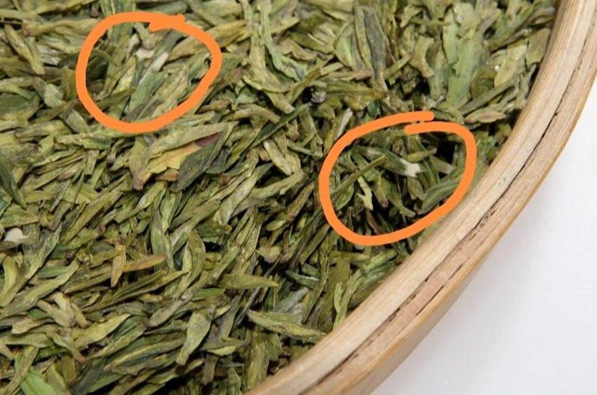龙井干茶表面隐现茶毫,茶叶里面夹杂着一些如棉絮状的"小白球",这都