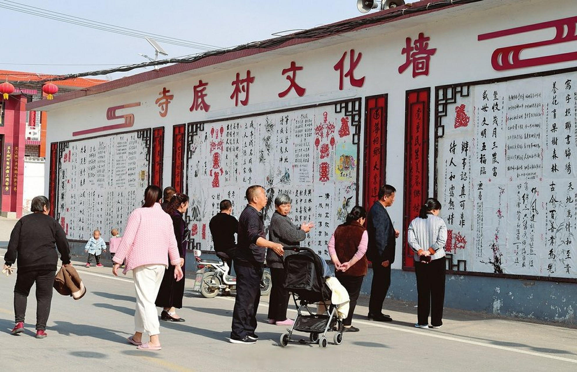 【乡村文化墙 新风扑面来】3月14日,闻喜县侯村镇寺底村村民正在欣赏