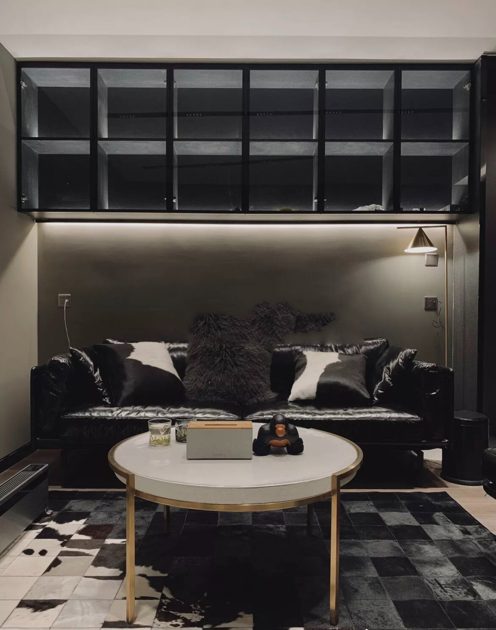 黑色沙发选地毯小技巧,同色系搭配法 油蜡皮黑沙发,圆形白茶几,再搭配