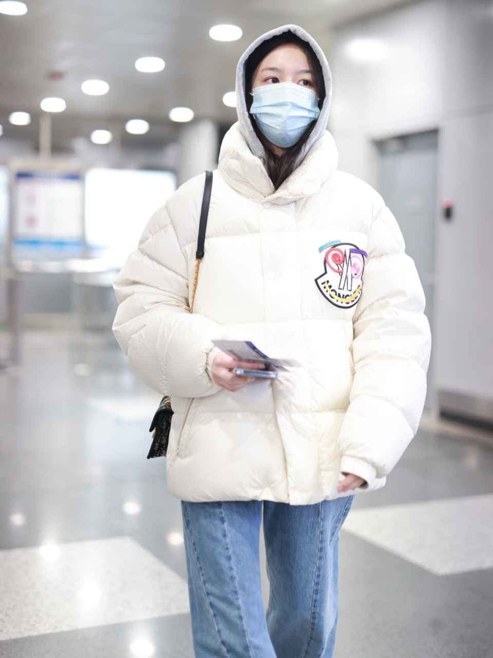 10现身机场: 身穿白色短裤立领羽绒服,内搭灰色连帽卫衣 浅色阔腿牛仔