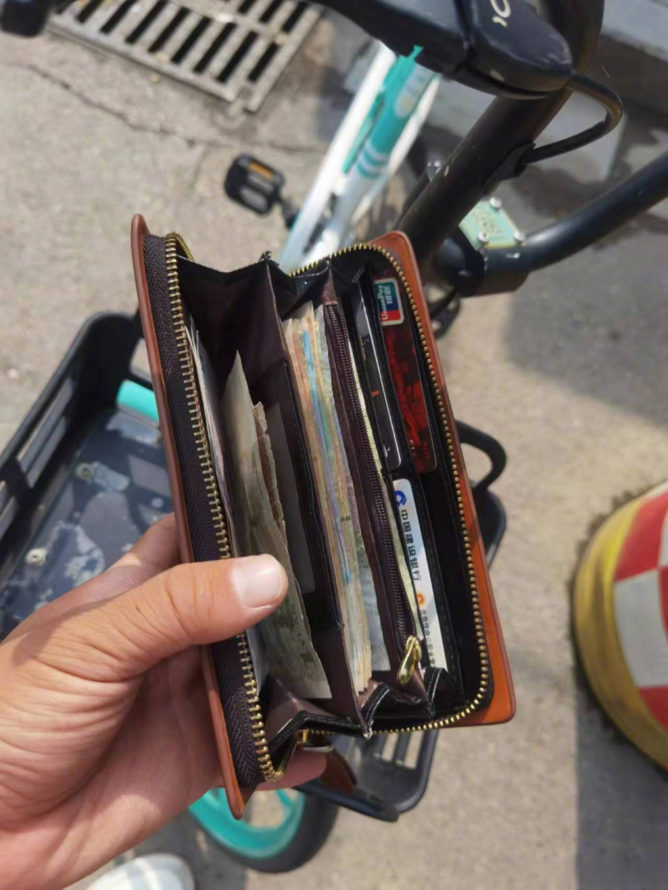 到万柏林和平南路太化新光小区门口时,发现青桔单车车筐里有一个钱包