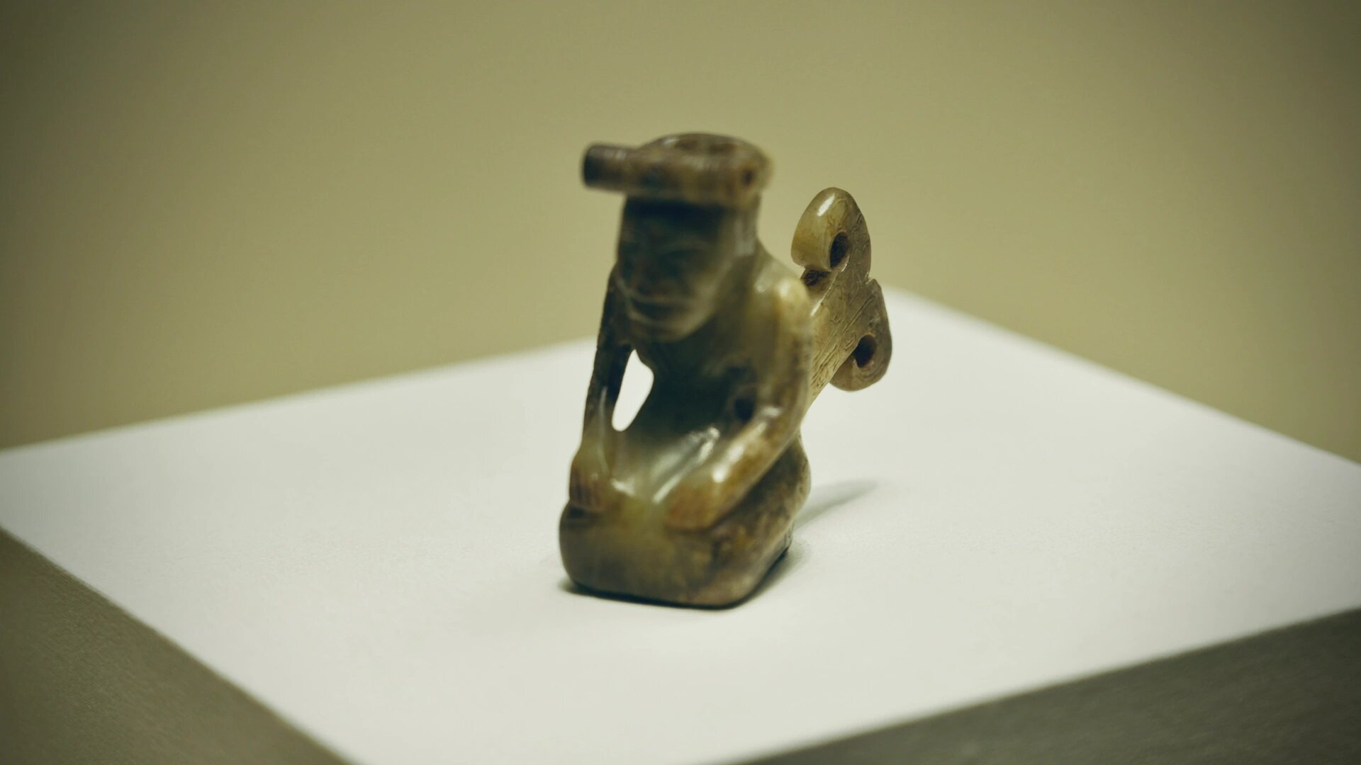 【文物尺寸】高7厘米 黄褐玉 【文物描述】 玉人呈跽坐状,腹前有蔽膝