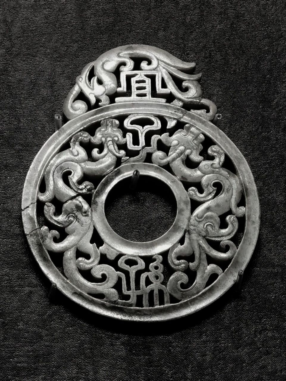 廓内镂空雕琢雌雄双螭,双螭相对,体态矫健,呈s形栖于璧内两侧