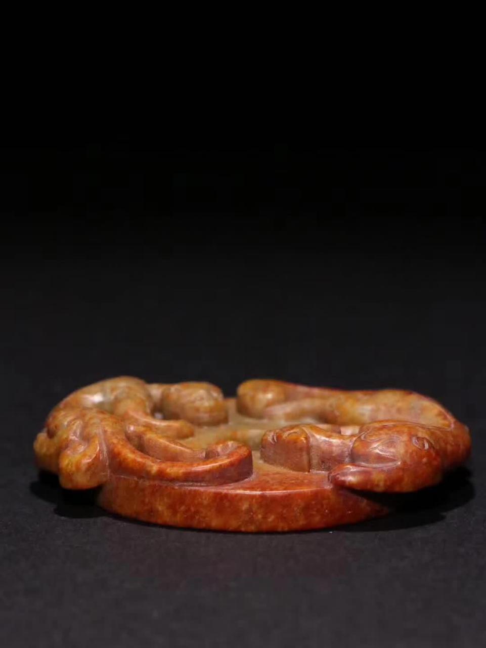 自明代的和田黄玉《双螭龙》玉璧,规格精巧,宽度为6.6cm,高度为5.