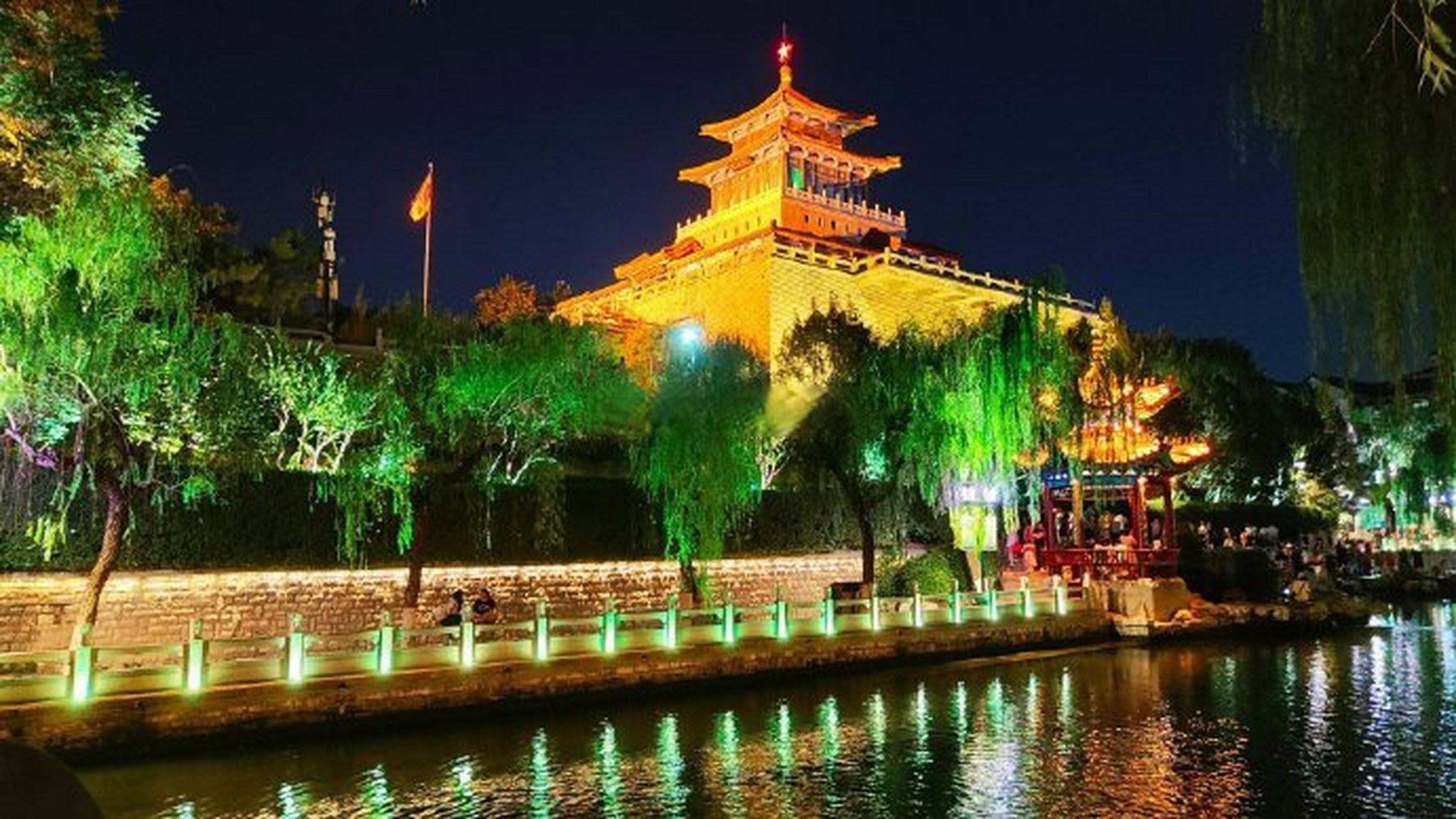 夜幕下的护城河公园灯光璀璨,夜色阑珊,凉风习习,游客们乘坐在游船里