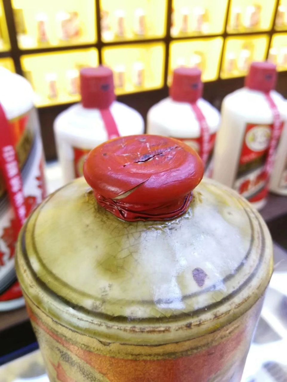 60年代茅台当时以矮嘴黄酱为主,矮嘴黄酱盖子木塞,外面包了一层荷色