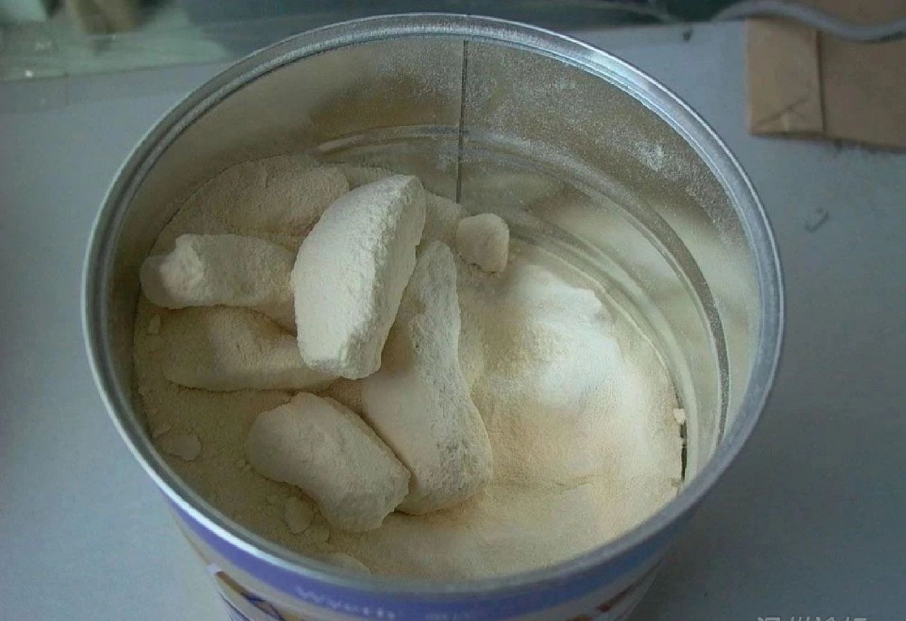 真正的"结块"是奶粉聚集成团,不能用力拨开的块状物.