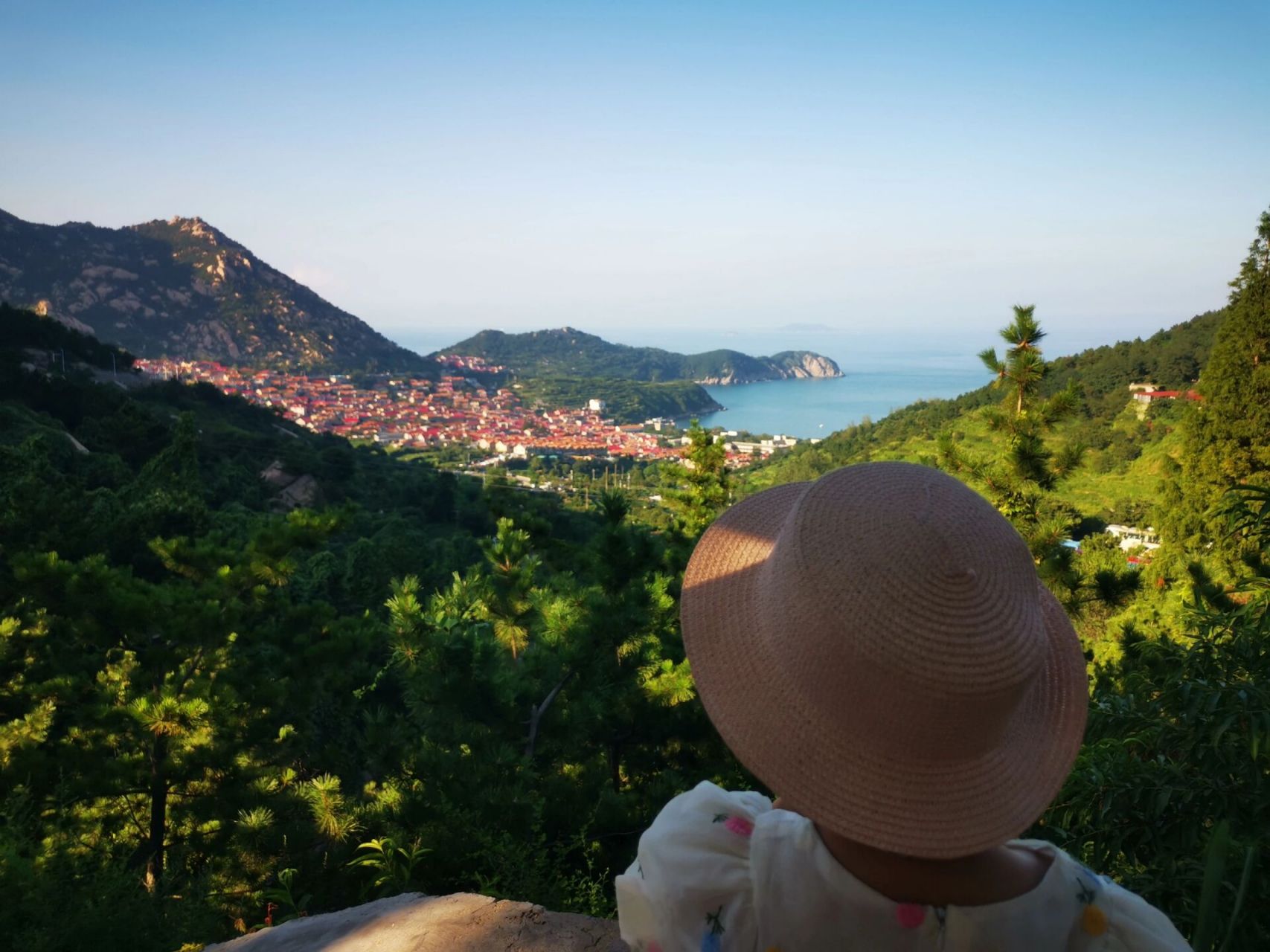 青岛崂山青山渔村 你看这个小渔村 它三面环山一面临海, 成片的红色