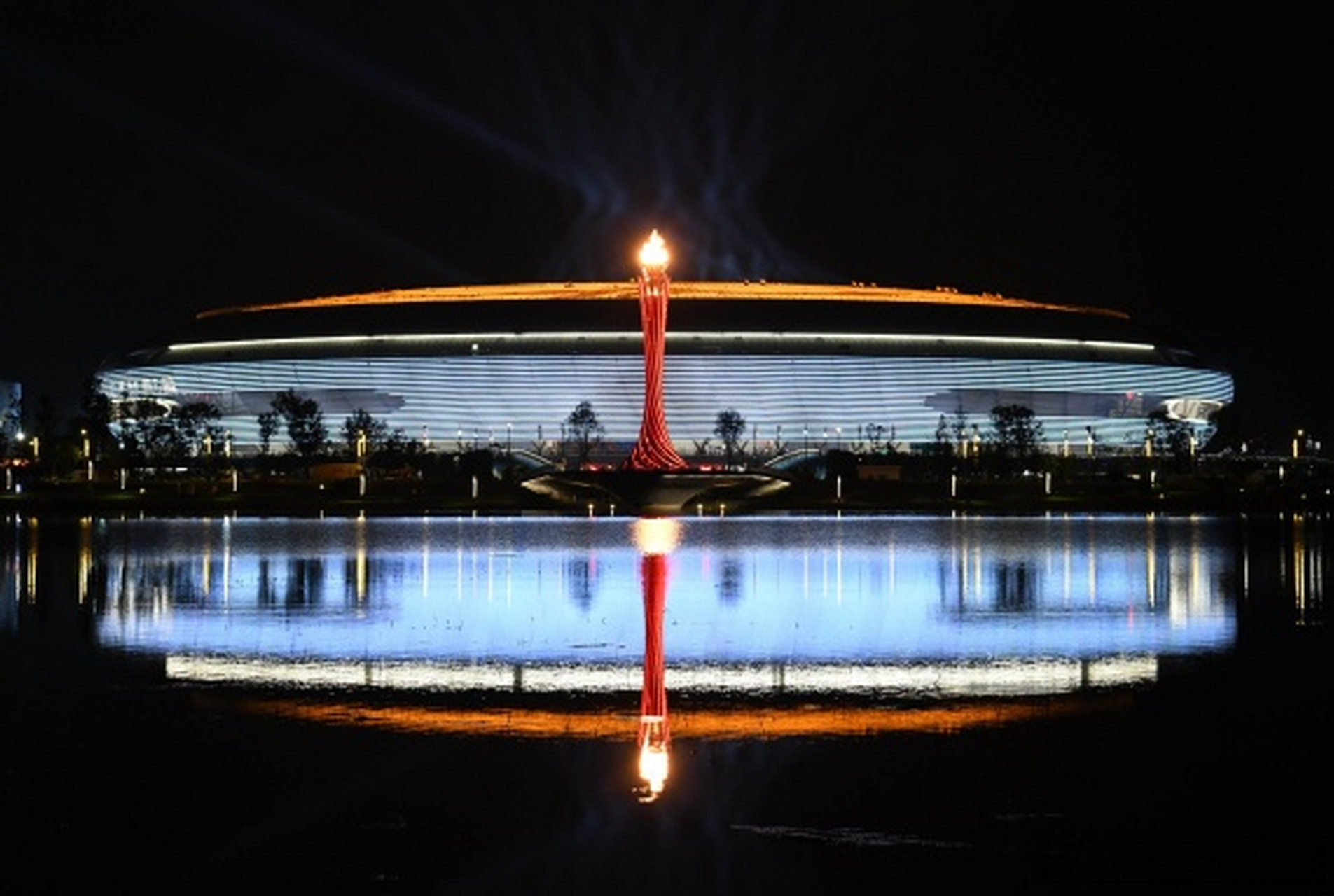 成都大运会主火炬点燃 31支"蓉火"火炬伸向"太阳神鸟"图案的圣火盘