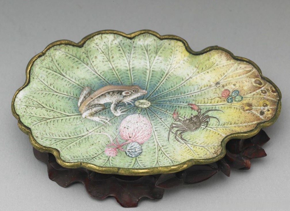 器表描绘细密的荷叶脉理,叶缘若残破状,叶面绘浮萍,青蛙,磅蟹等水族