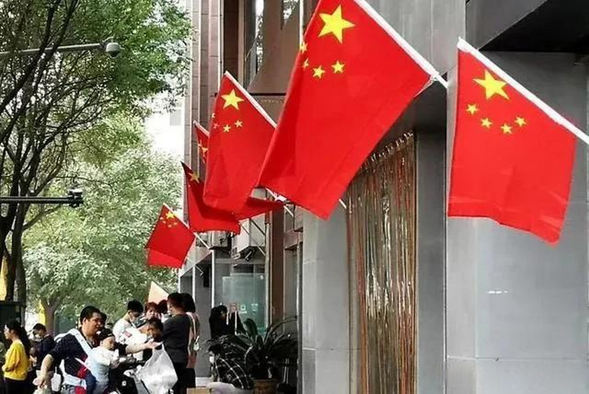 一位店主将国旗整齐挂在店铺门口,以表达自己的爱国情怀.