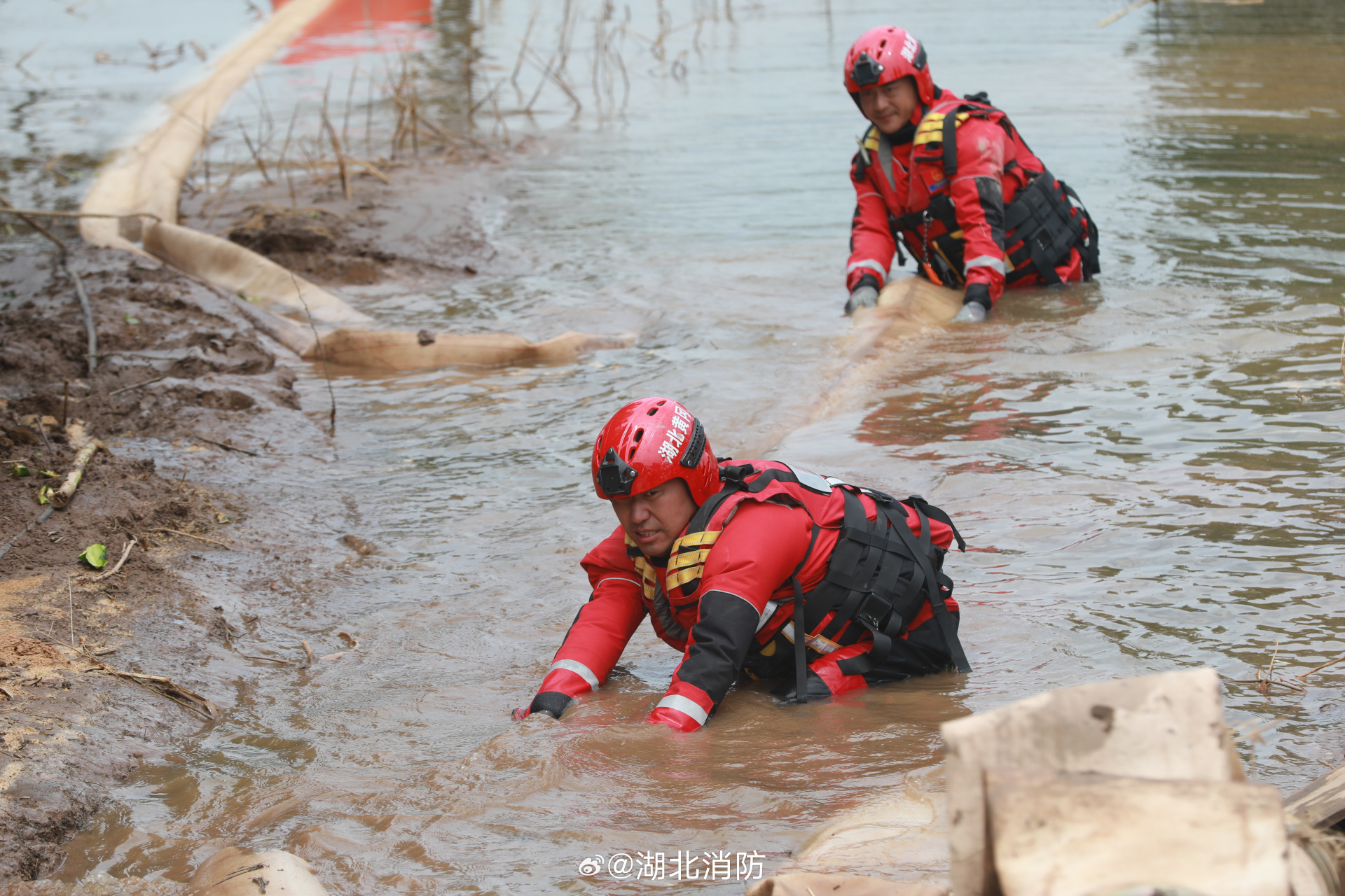 湖北消防排涝除险在一线# 洞庭湖团洲垸前线,消防员们身着厚重的成