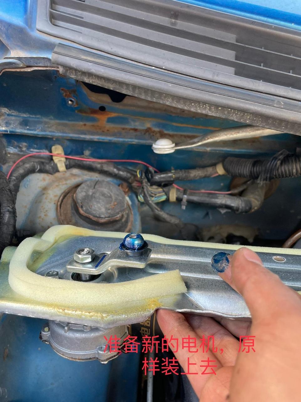 铃木北斗星更换雨刮器电机分享: 1.打开机盖,拔下马达电源插头 2.