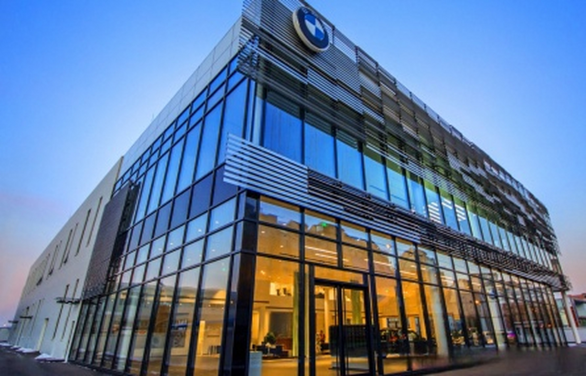 天津宝马4s店展厅将面向道路的墙面装修成玻璃材质,使整个展示厅像一