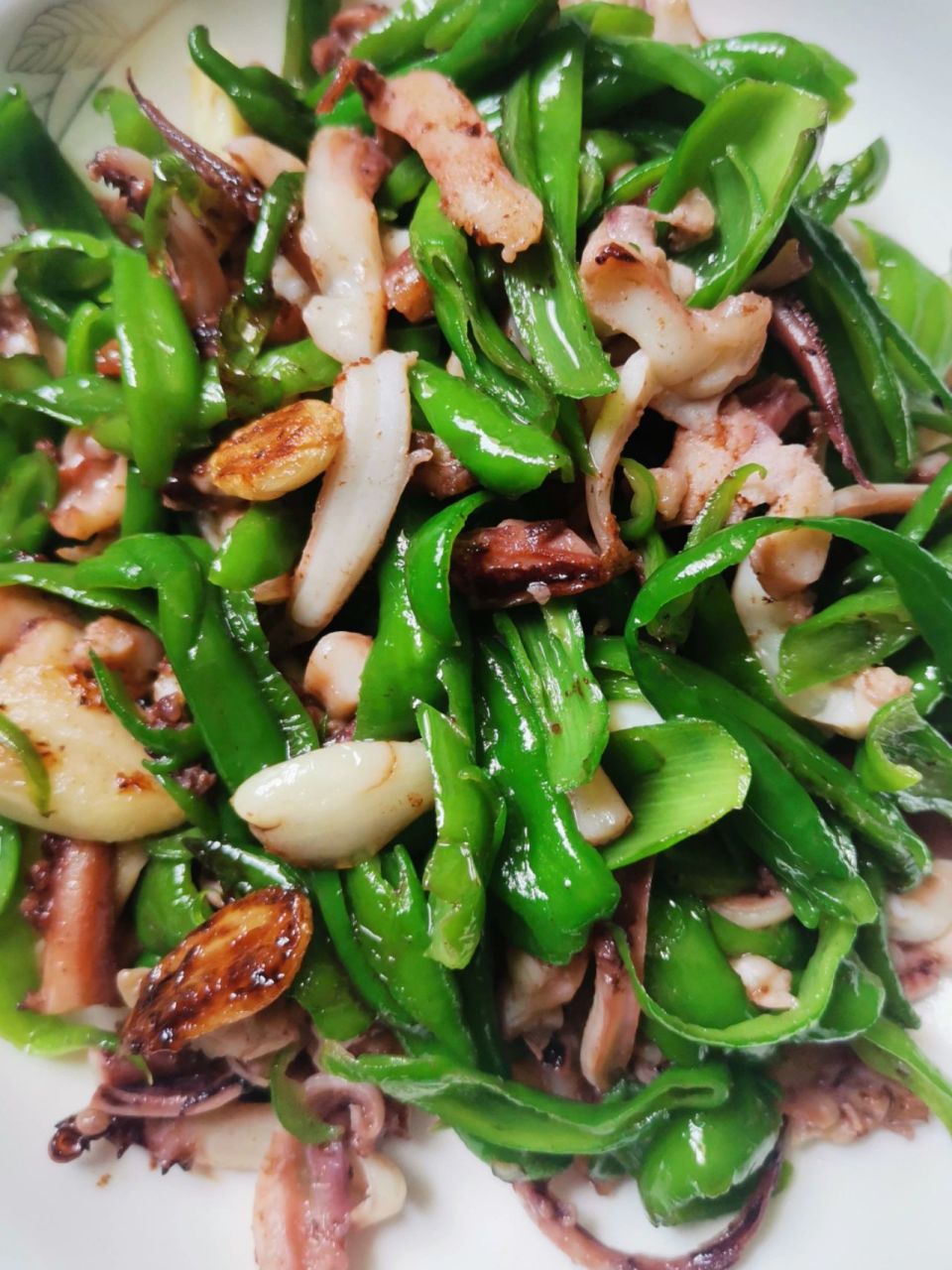 青椒炒鱿鱼丝 食材:鱿鱼二只,青椒一把,蒜子四粒 步骤: 1,鱿鱼去除