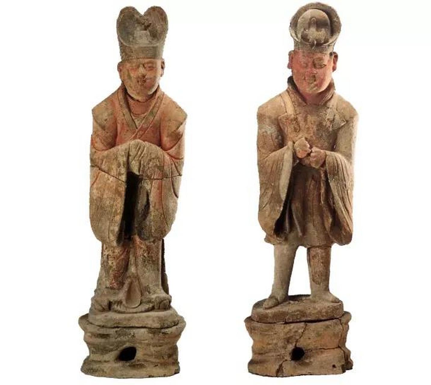 头戴黑色进贤冠,身着红色阔袖交领长袍,袍垂足面,下饰