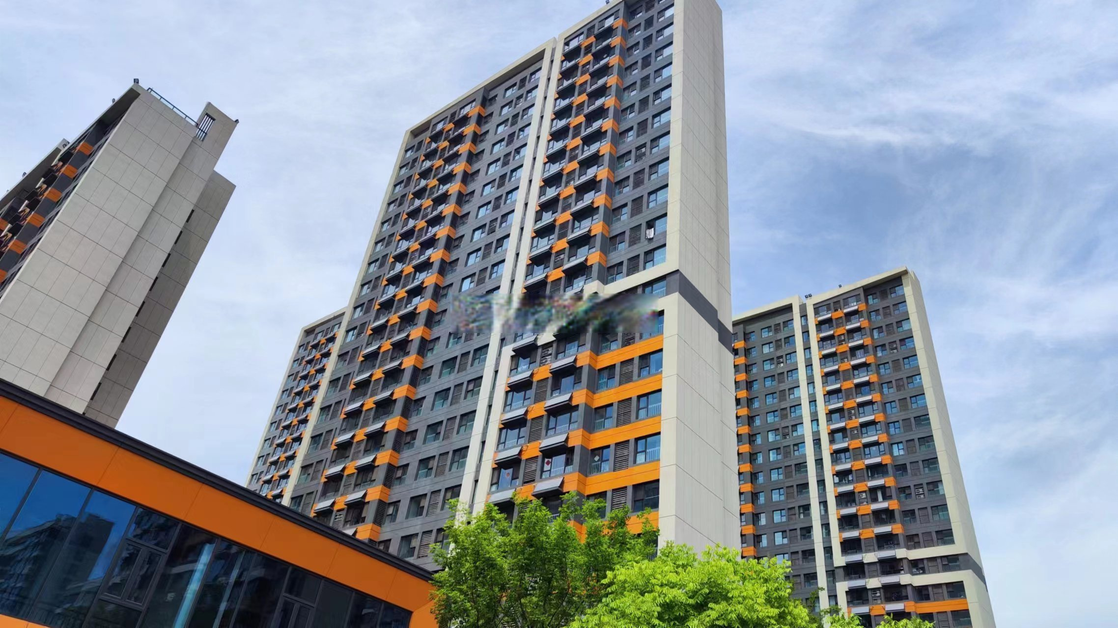 庐阳区学林雅苑实景图,外立面和大门采用了大量橙色,色彩非常鲜艳,由