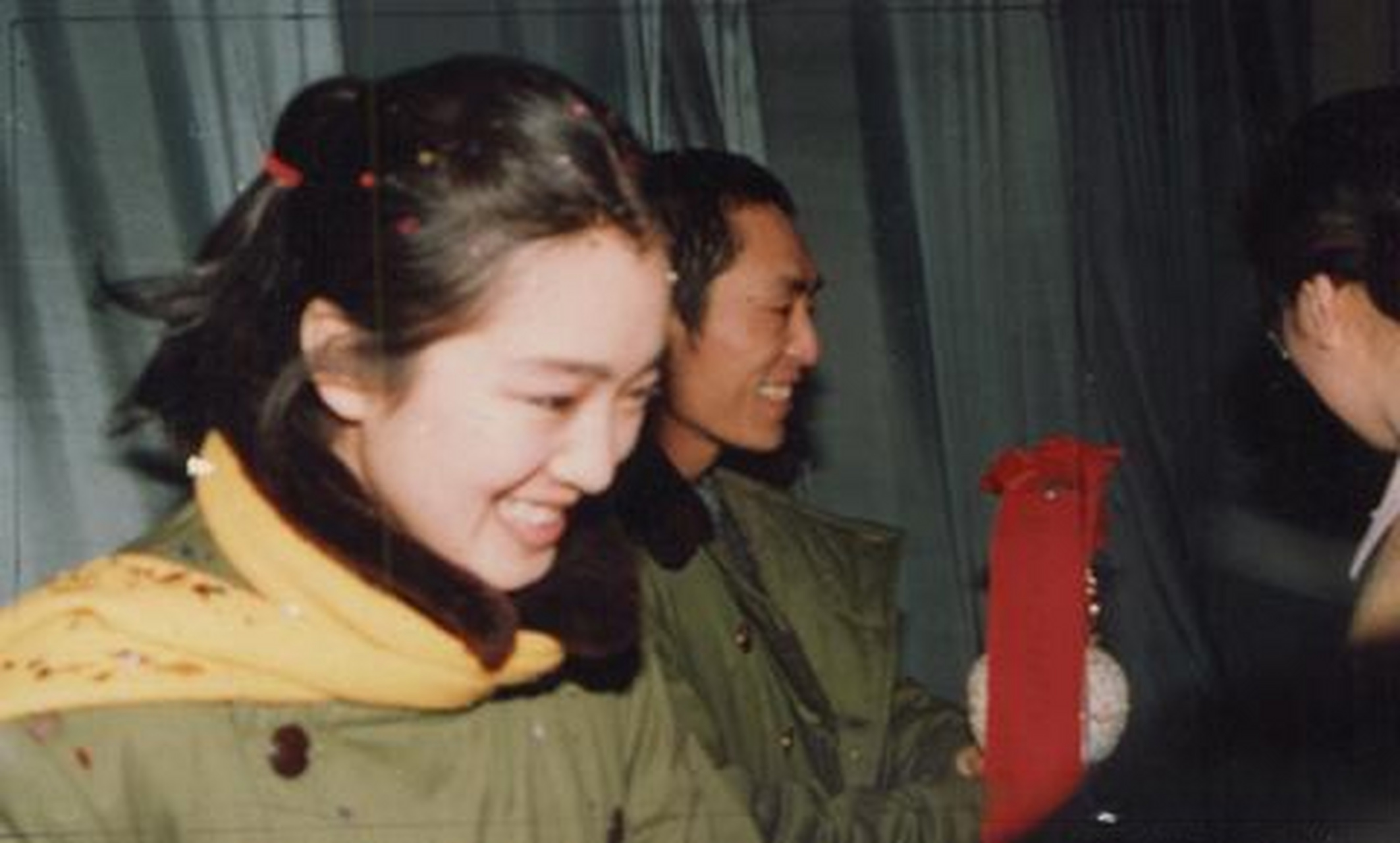 1988年,穿着军大衣出席红高粱首映的巩俐和张艺谋