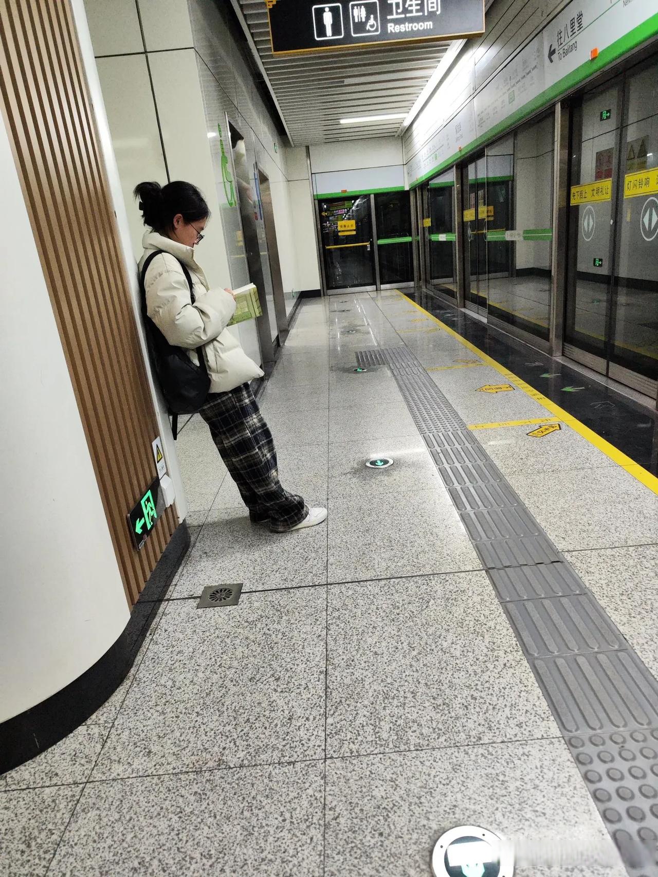 在地铁站等车时,大家都低着头玩手机,只有这个小姑娘捧着本书在看!