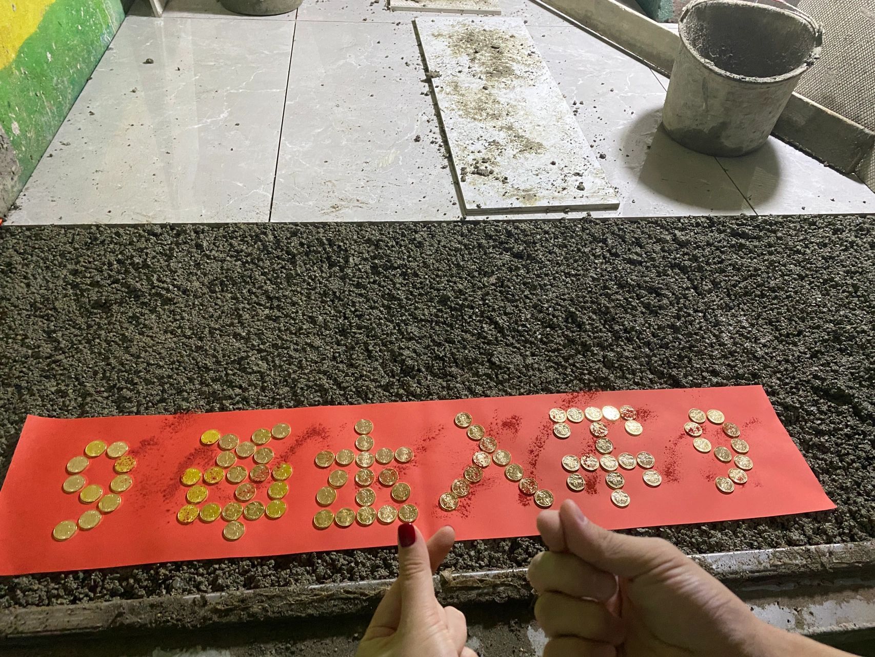 过门石下面用的是88颗金色5毛硬币摆的"出入平安",撒上朱砂,出门66