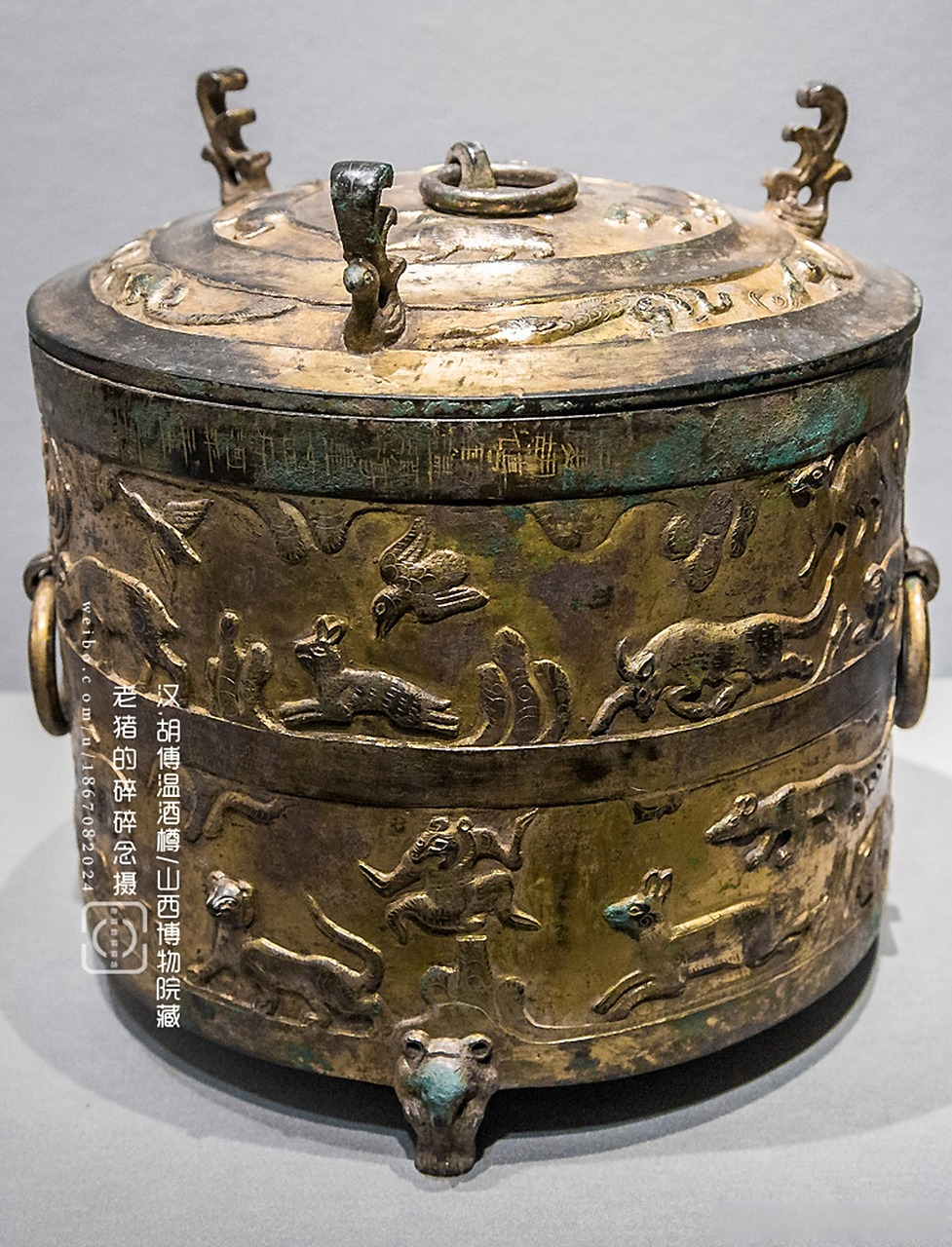 酒樽的质地均为青铜,且通体鎏金,器盖中央有一提环,周围有三个凤形钮