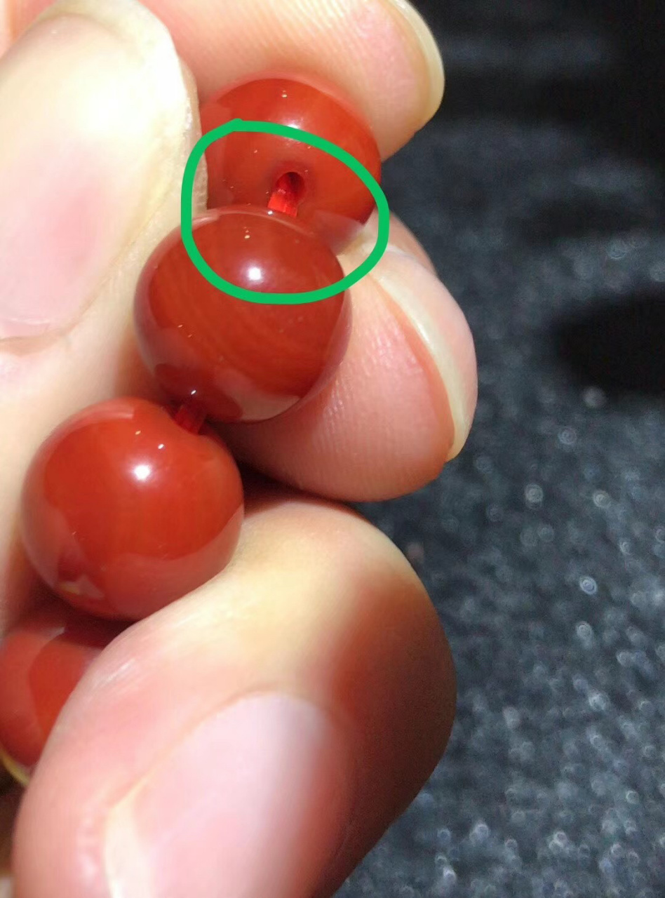分享一下烤色玛瑙冒充南红的特点:孔道口透明玻璃状的圈圈8715