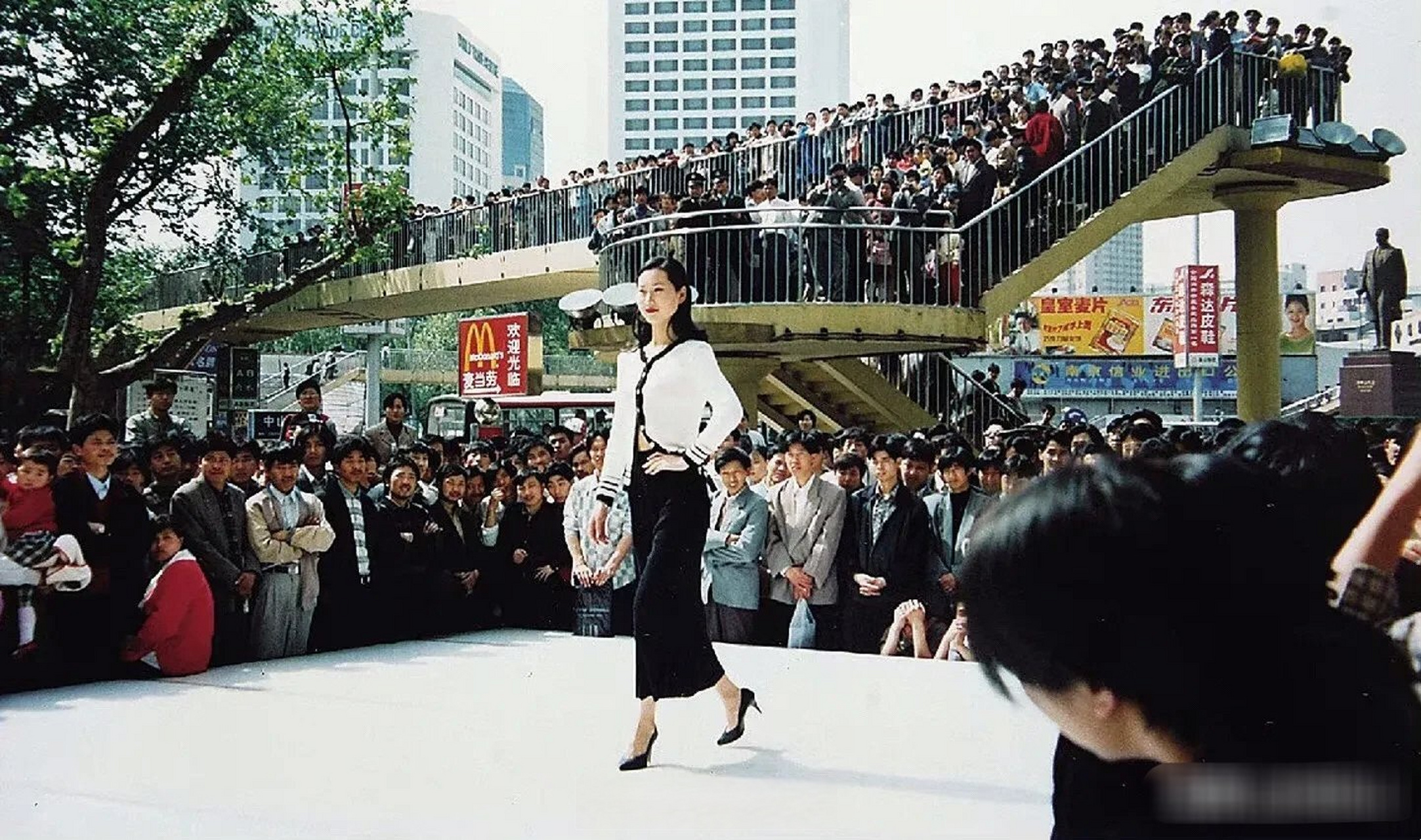 上世纪,南京新百百货大楼门口的一场走秀,背后就是南京著名的金陵大