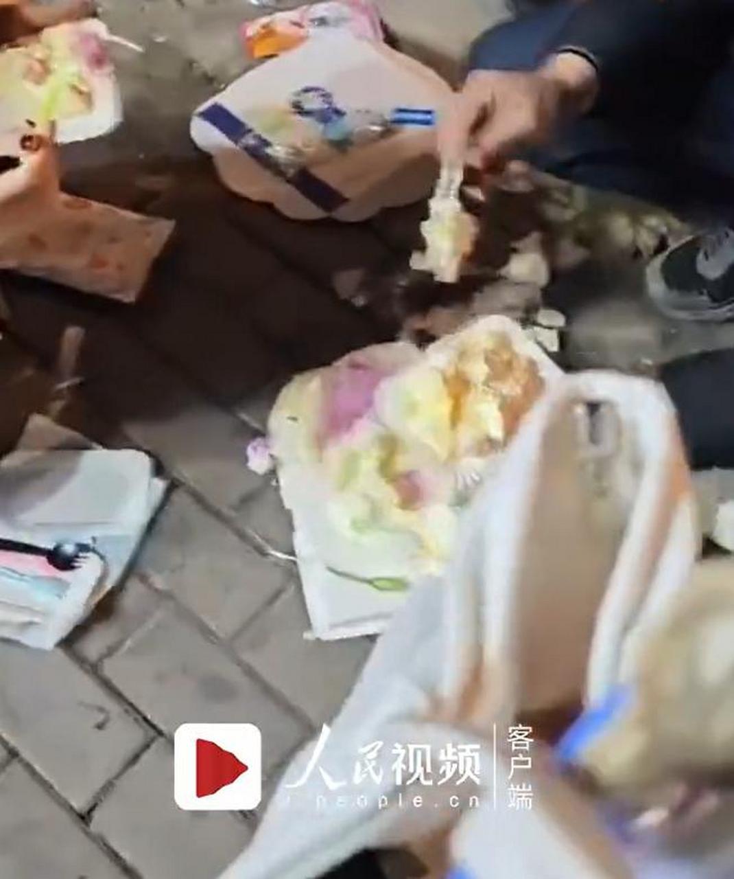 女子看着碎成一团的蛋糕,顺手戴起生日帽,与家人一起就地过起了生日.