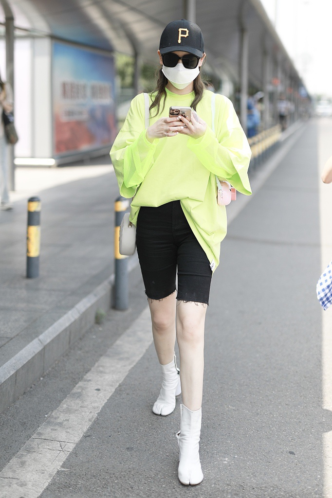 她穿着荧光绿大卫衣时尚亮眼,搭配健美裤秀嫩白美腿,踩分趾靴气场十足