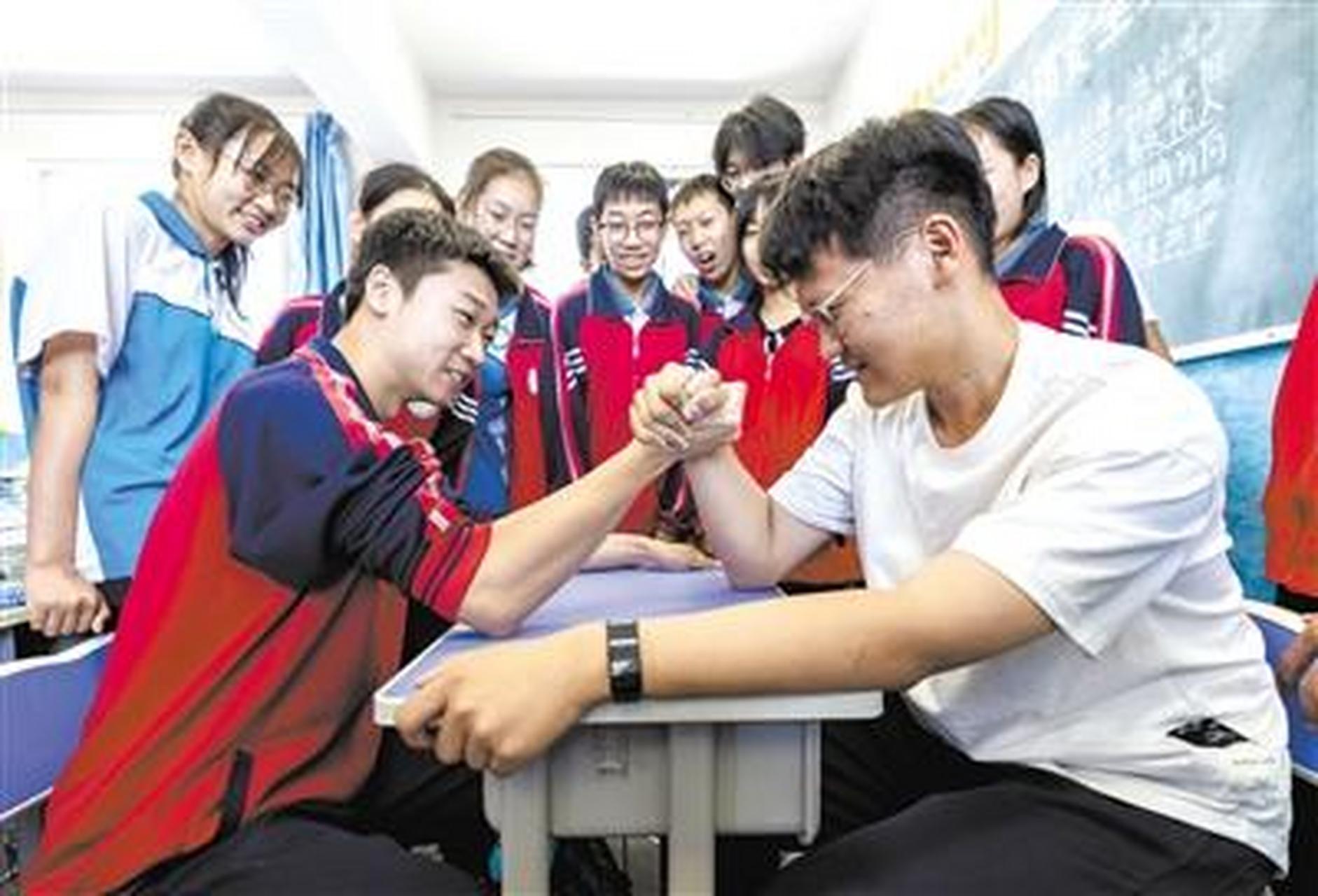 6月13日,内蒙古呼和浩特市第二十七中学初三年级学生在课间进行掰手腕