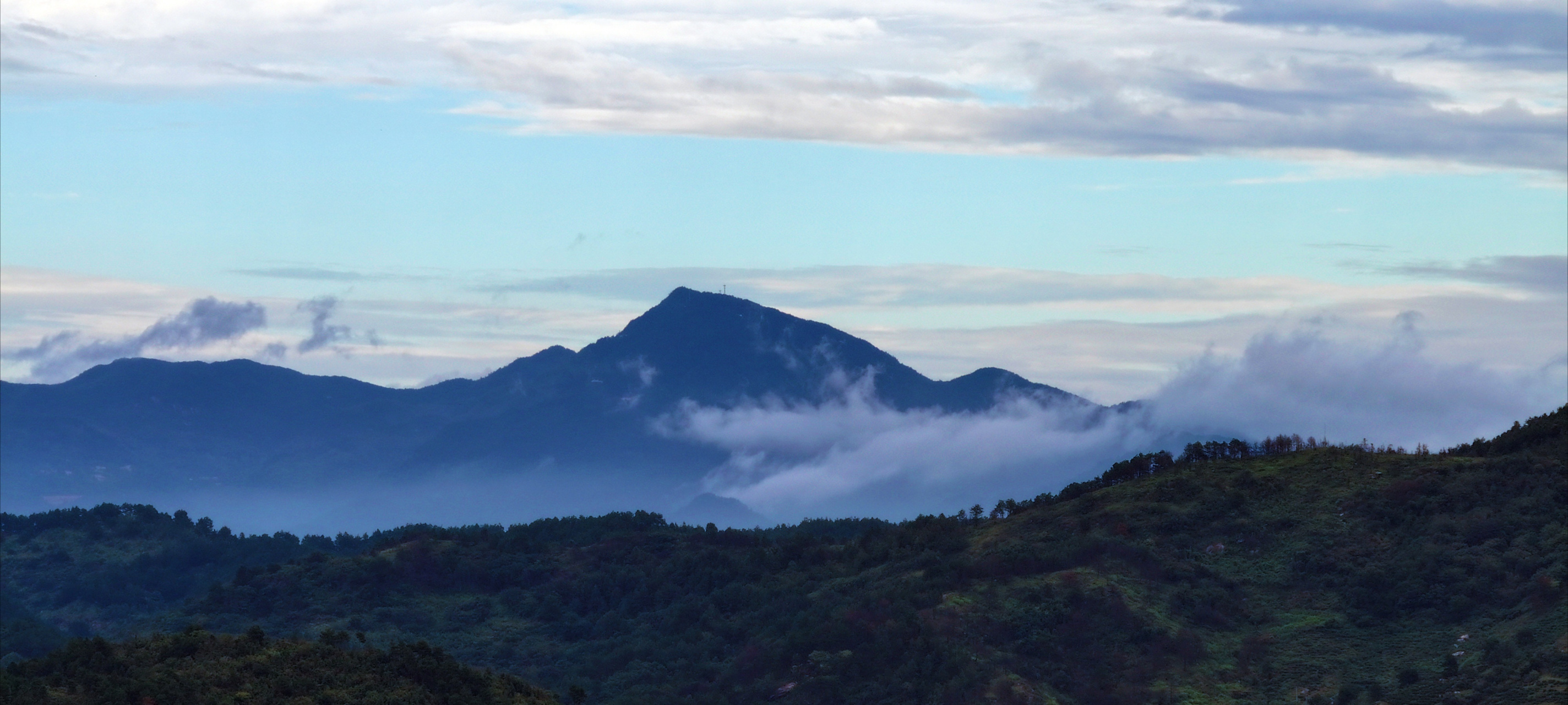 在长焦镜头下,大别山脉的风景秀丽,整体泛着深蓝,云在半山腰,如丝如