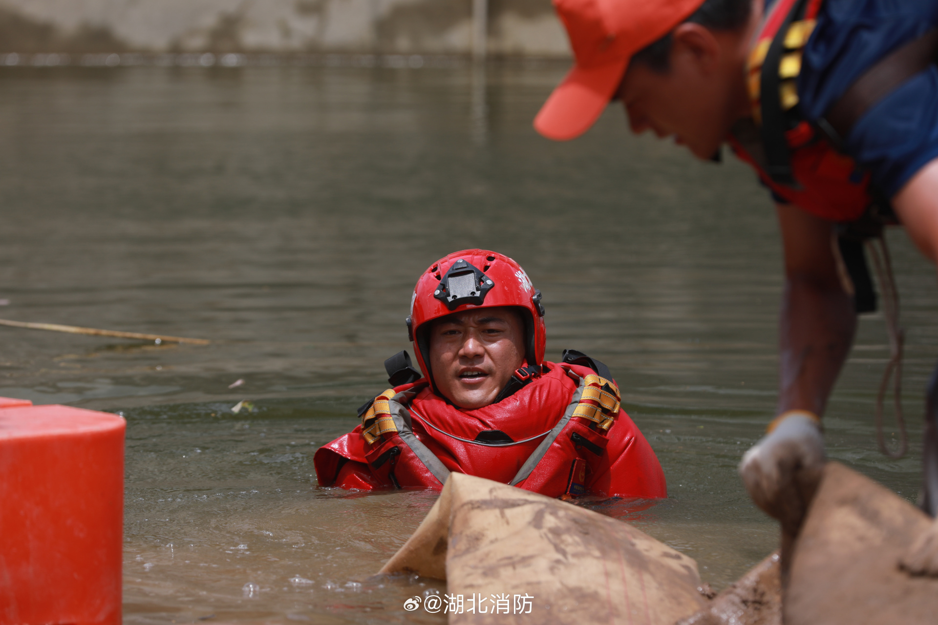 湖北消防排涝除险在一线# 洞庭湖团洲垸前线,消防员们身着厚重的成