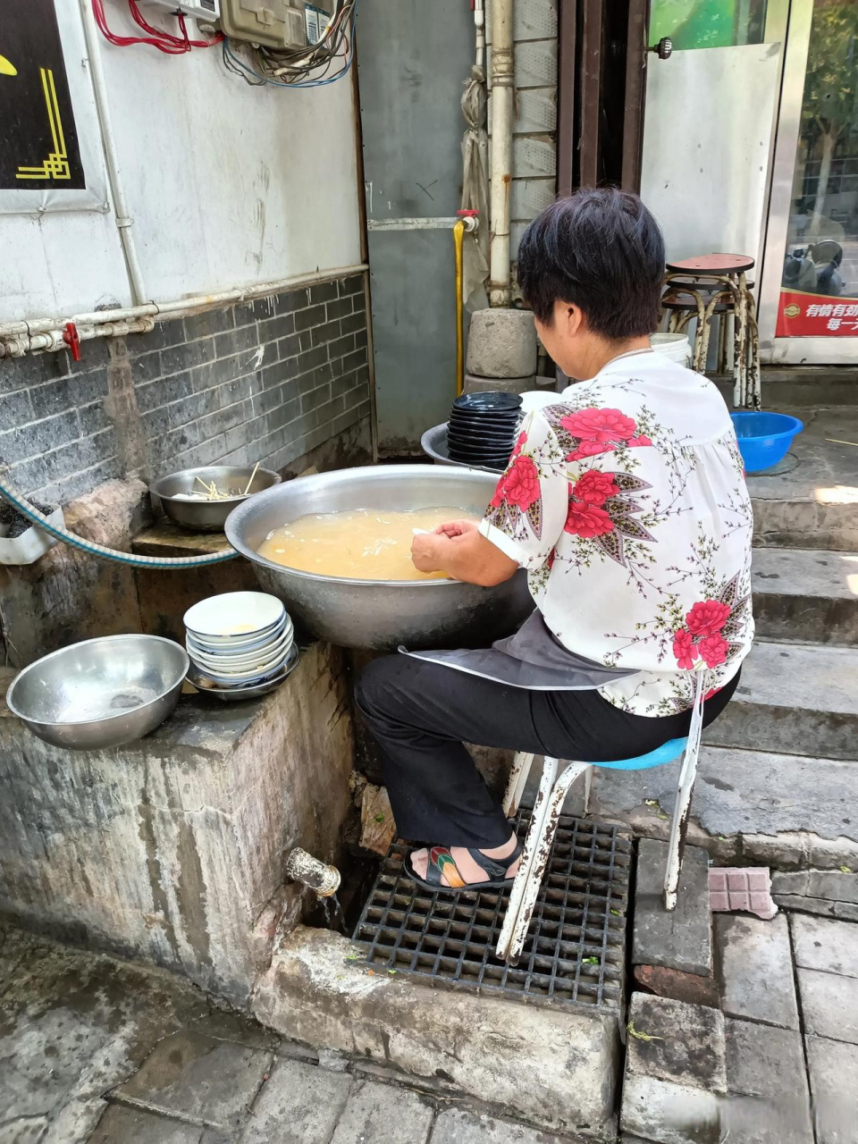 吃完饭,刚出饭店门,只见店家在洗碗和盘子,盆里的水真浑浊呀,瞬间肚子