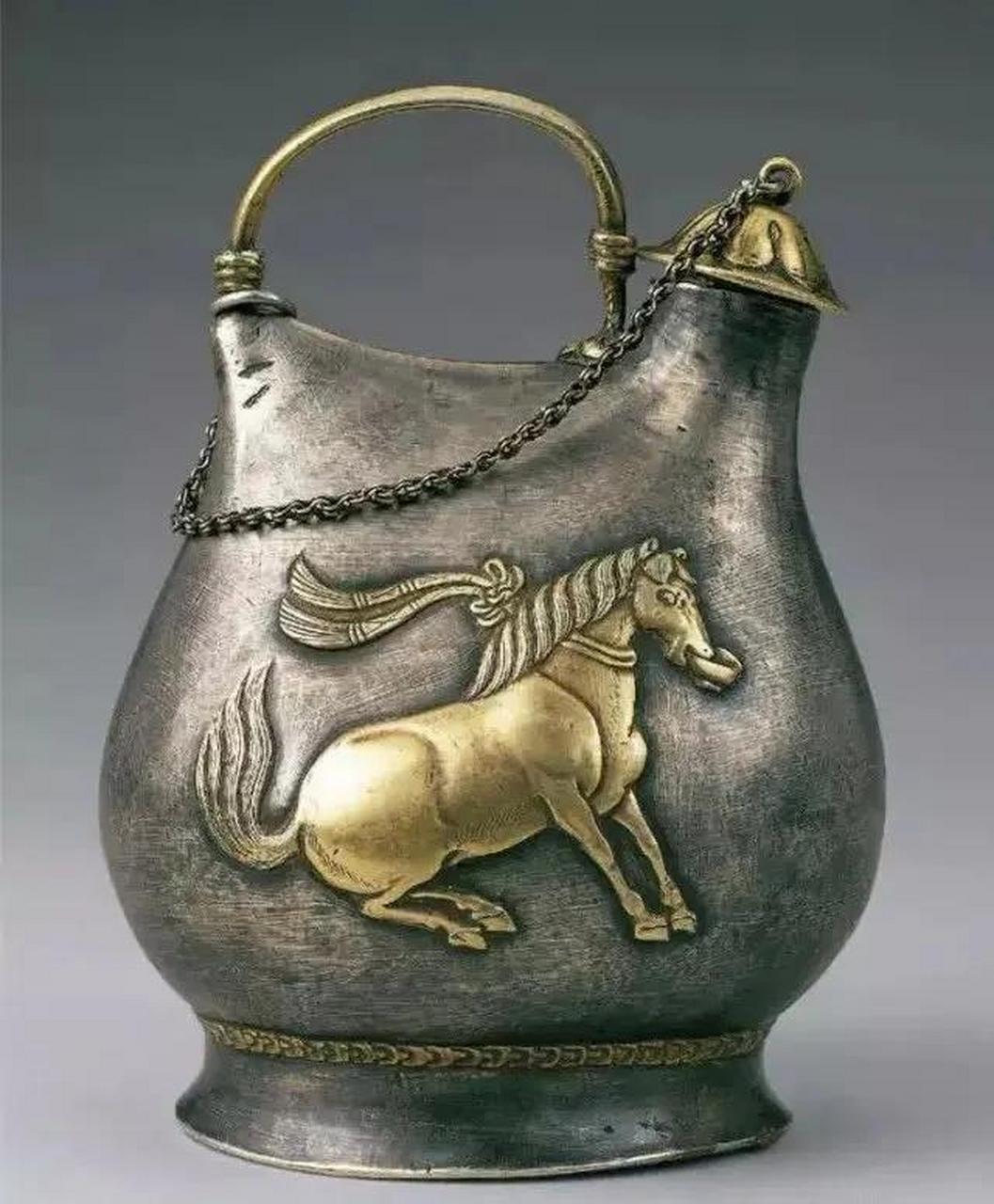 此壶仿游牧民族的皮囊式水壶造型,通高18.5厘米,口径2.2厘米,足8.