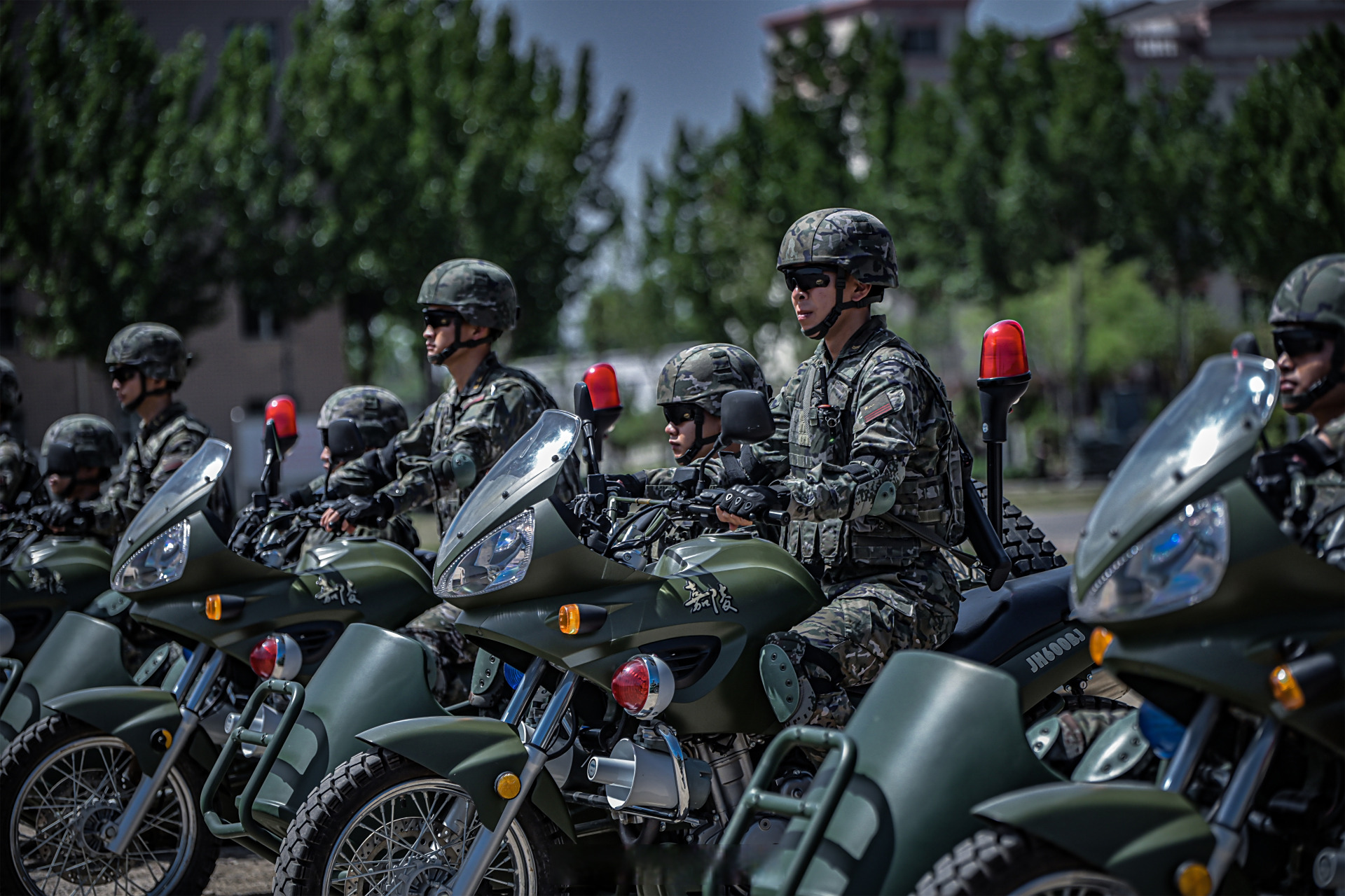侦察队员驾驶着摩托车在训练场上飞驰,时而变换队形,编队行进;时而抬