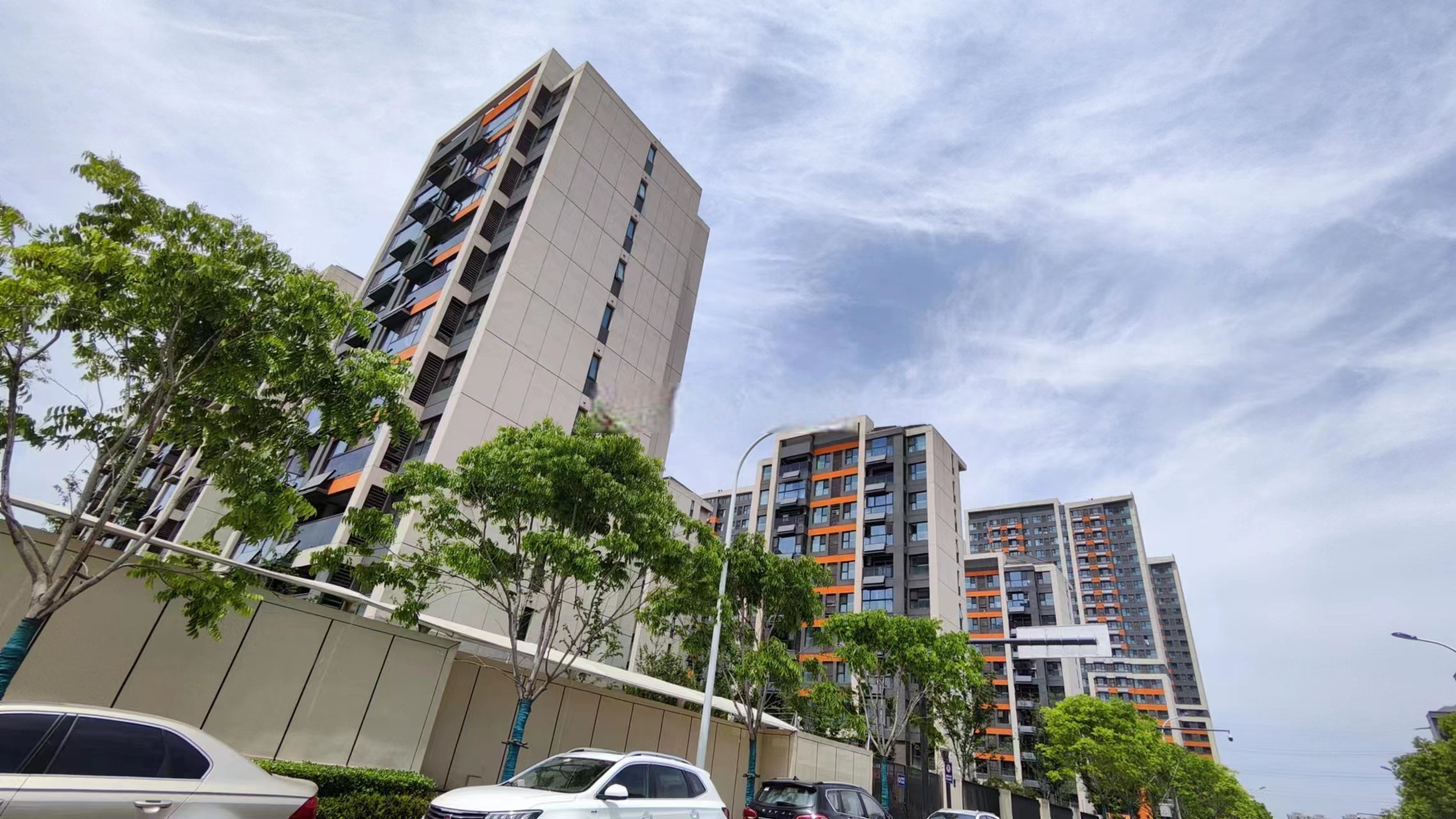 庐阳区学林雅苑实景图,外立面和大门采用了大量橙色,色彩非常鲜艳,由