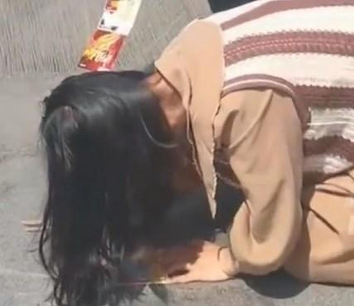 【财神庙前女子跪地刮彩票】4月23日,北高峰财神庙前,一位女子跪在地