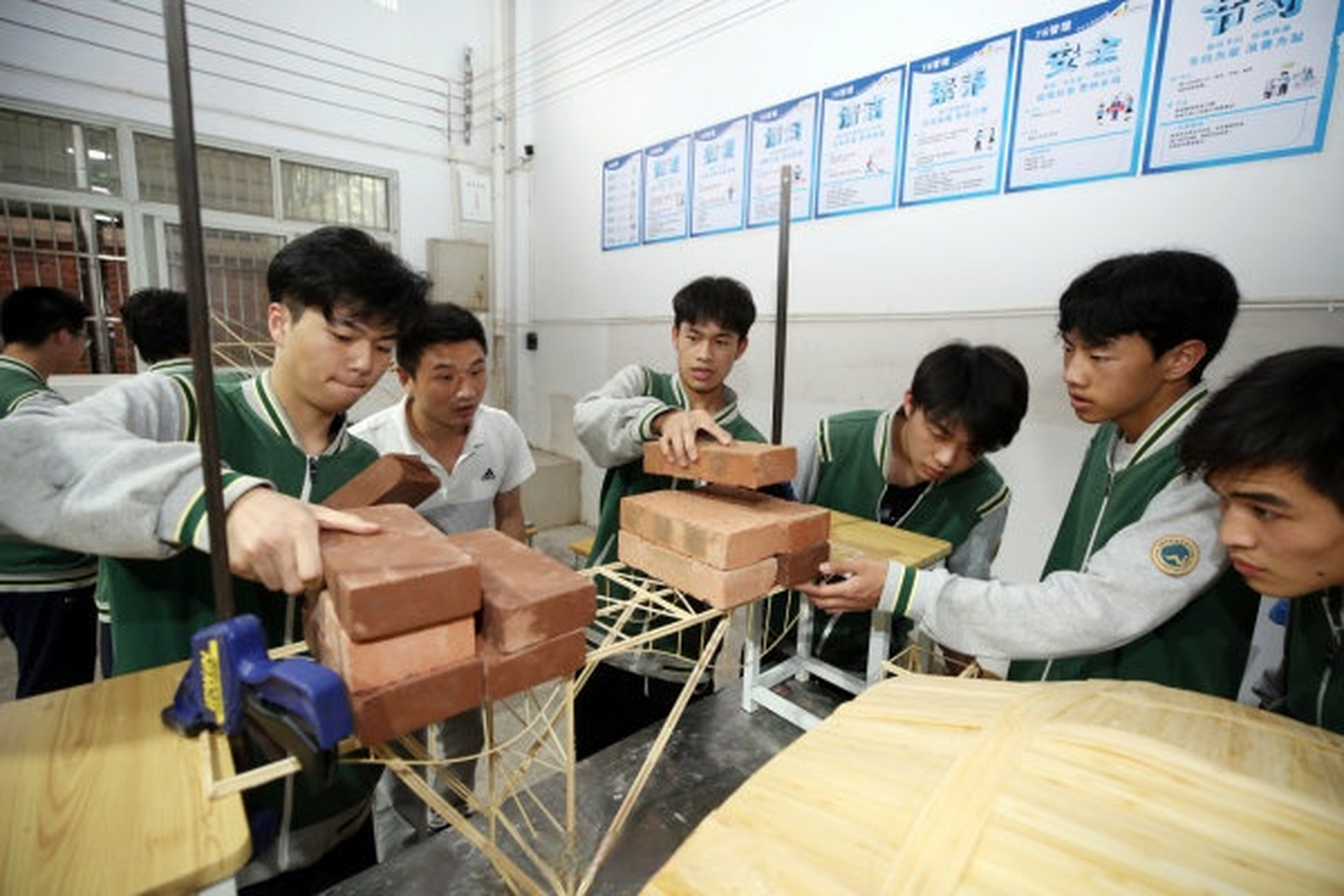 该校专业课老师正在指导,点评建筑工程施工专业学生的毕业作品