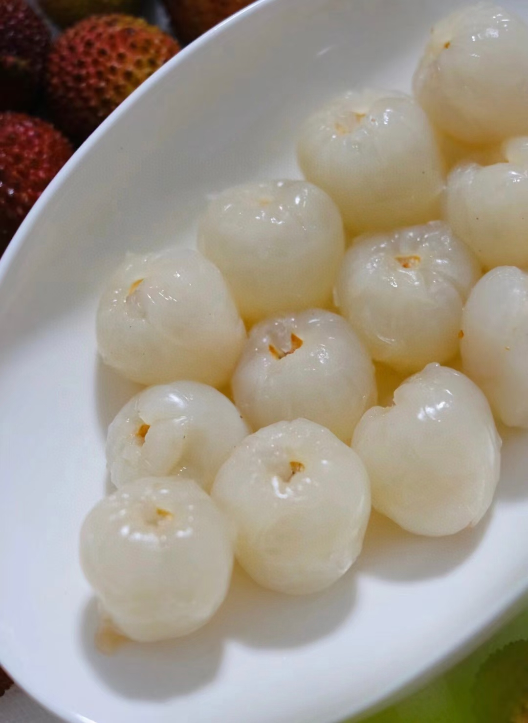 这个白色盘子上的荔枝,颜色各异,就像是大自然调色盘上的明珠